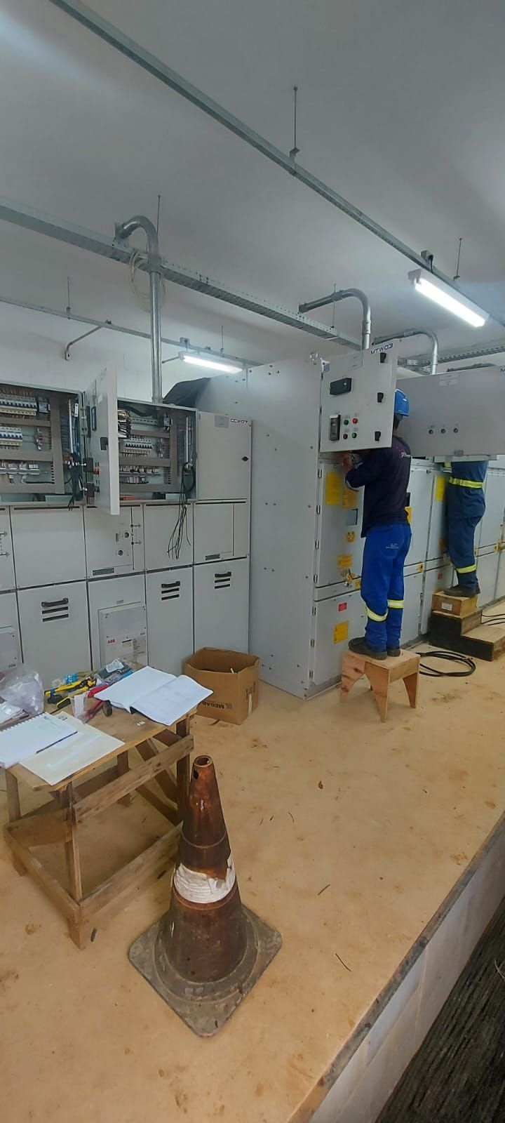 Um homem está trabalhando em uma máquina em uma sala.