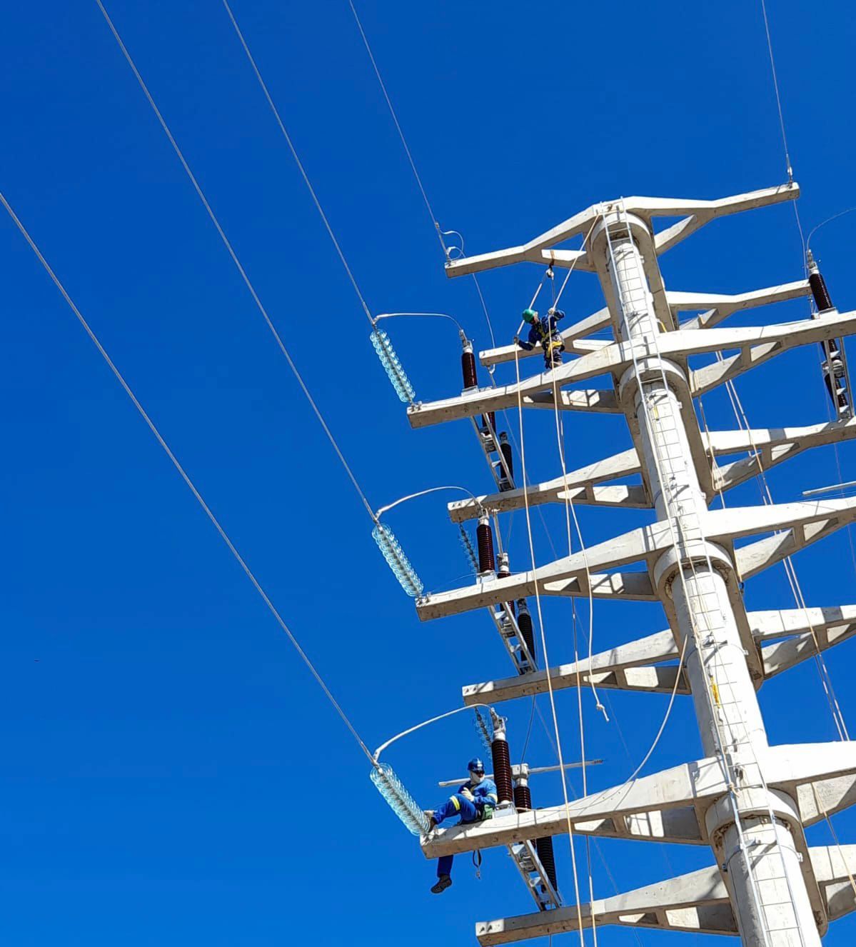 Um poste telefônico com um céu azul ao fundo