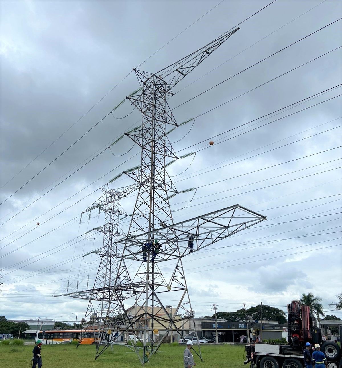 Uma grande torre de energia está no meio de um campo gramado