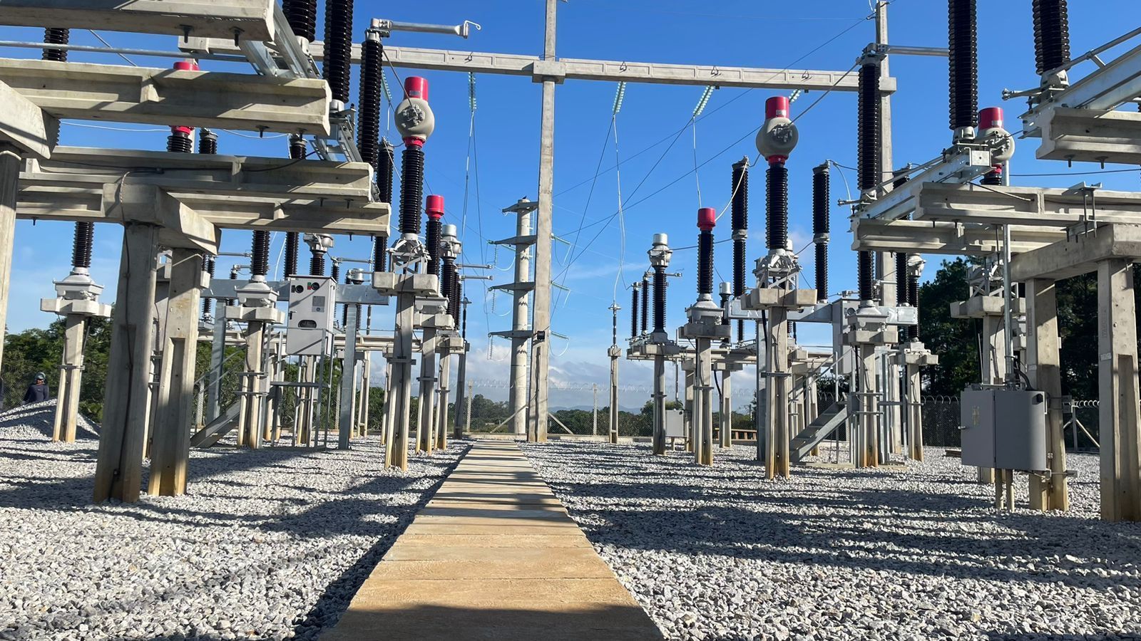 Uma grande subestação elétrica com muitos equipamentos elétricos.