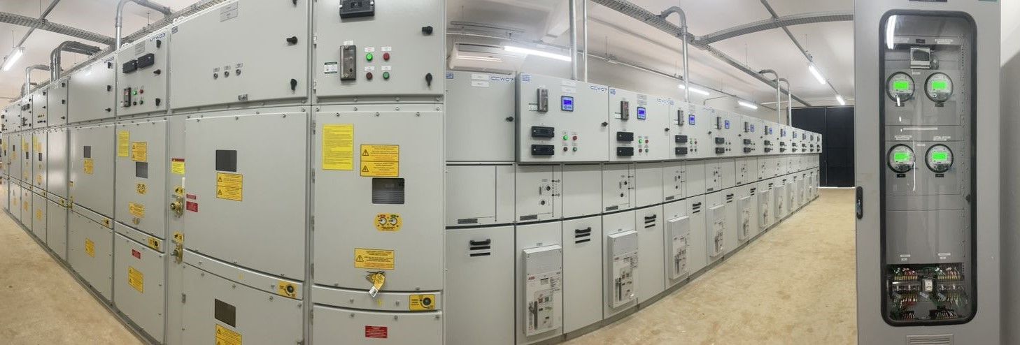 Uma fileira de armários elétricos estão alinhados em uma sala.