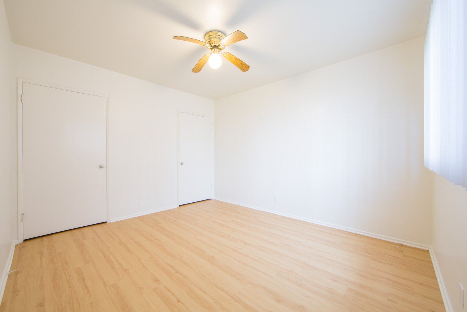 large studio with ceiling fan and storage closets