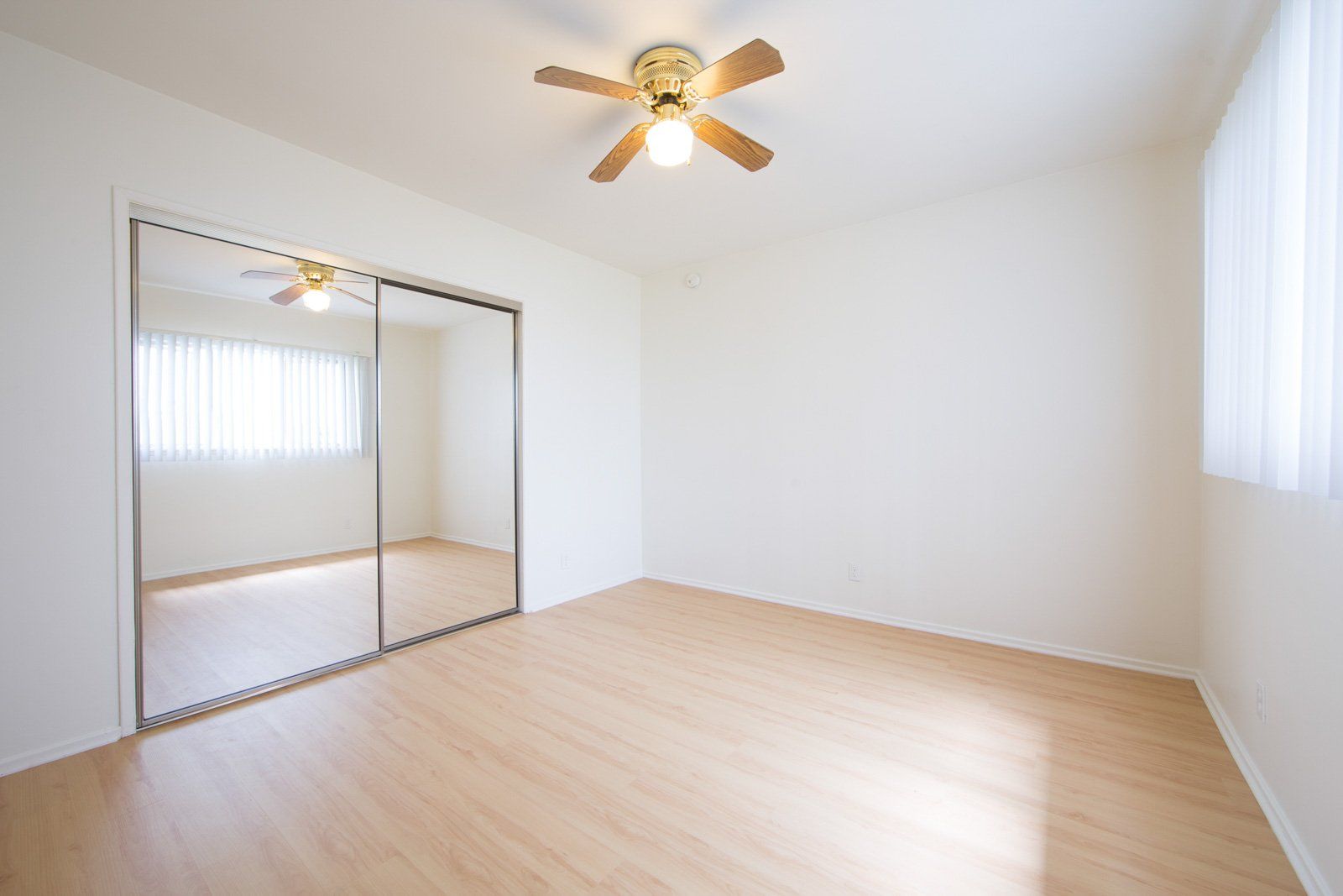 bedroom with large mirror closet and ceiling fan