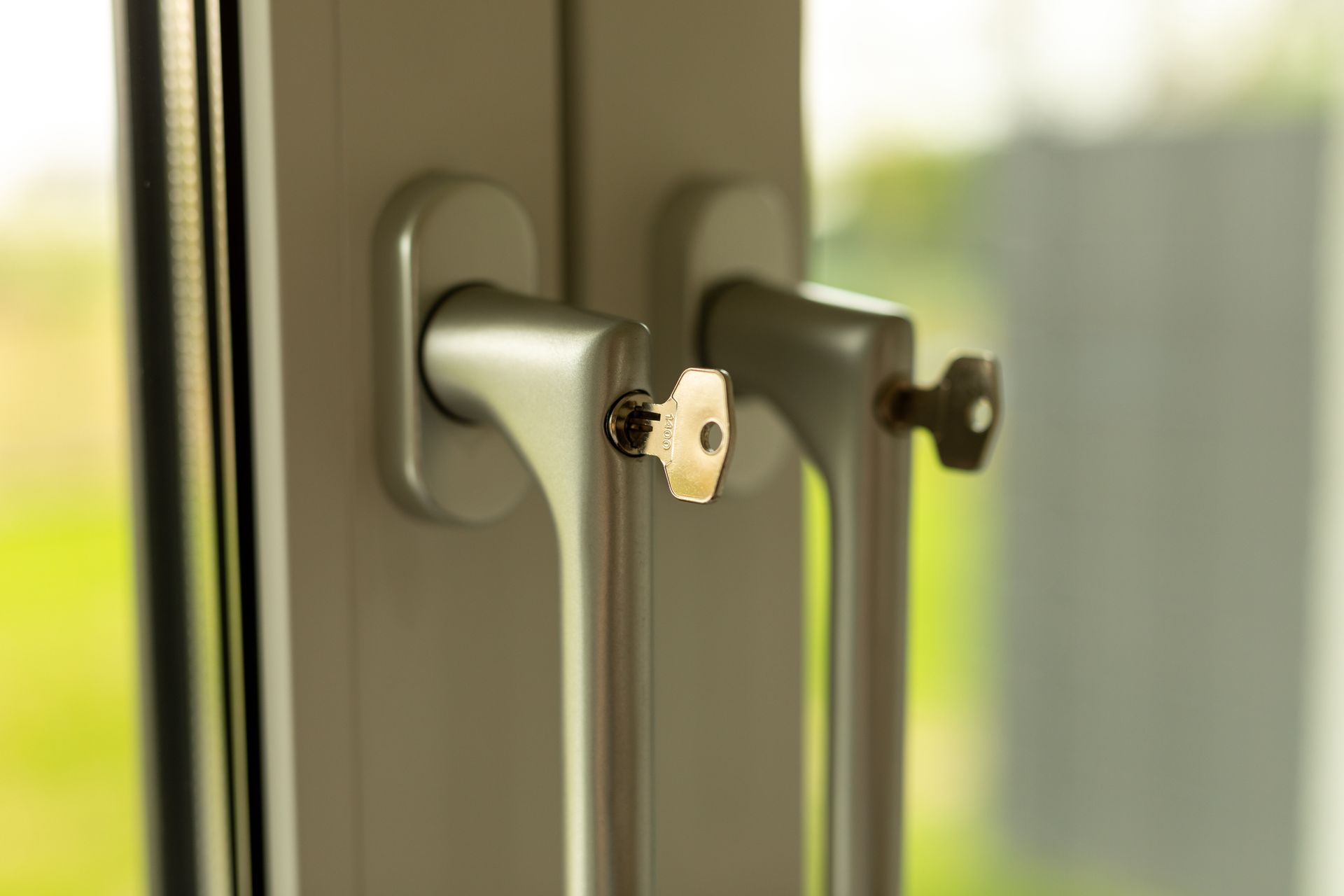 A close up of a window handle with a key in it.