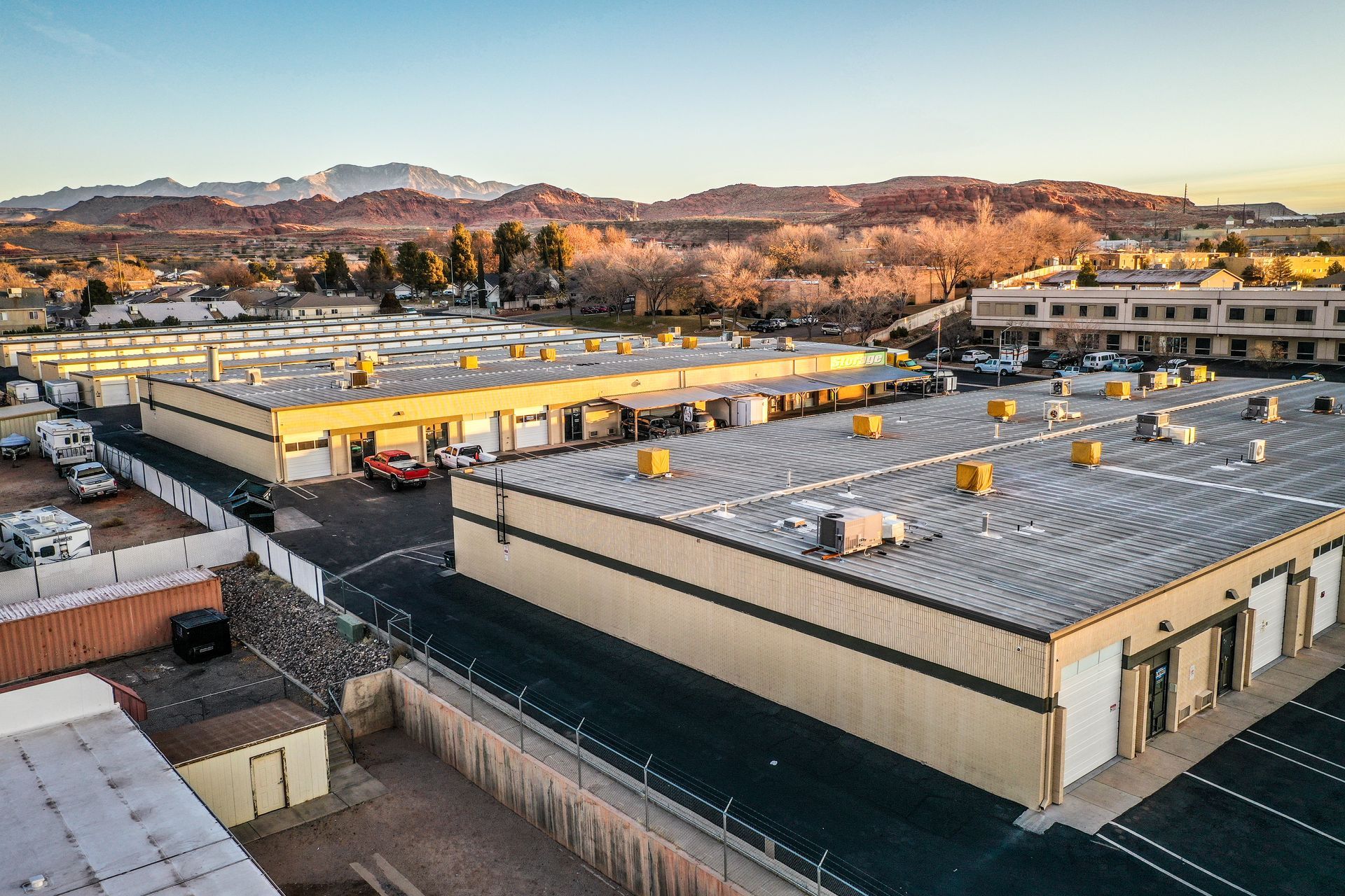 An aerial view of a large warehouse with mountains in the background.