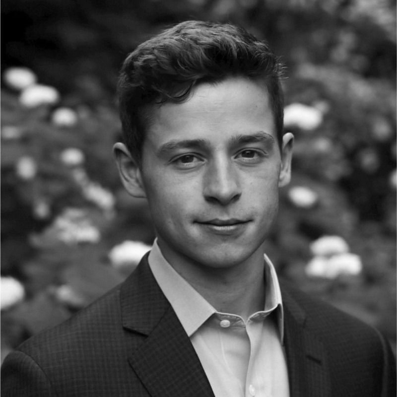 A black and white photo of a young man in a suit