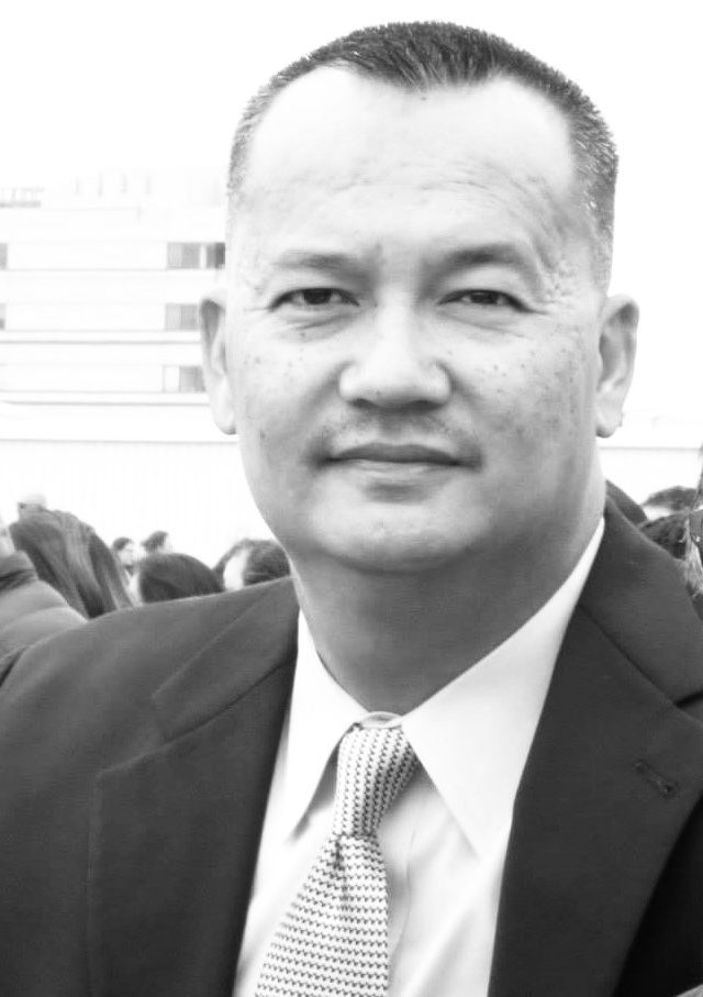 A man in a suit and tie is looking at the camera