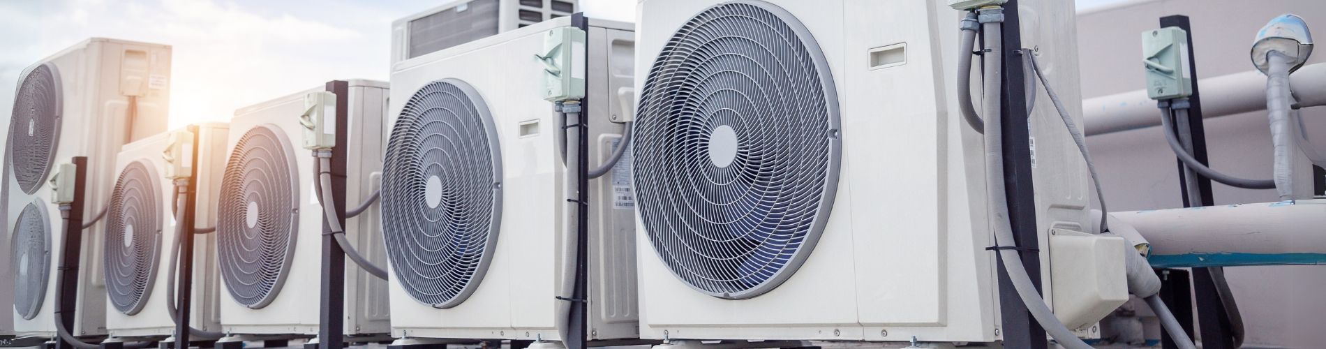 A row of air conditioners on the side of a building.