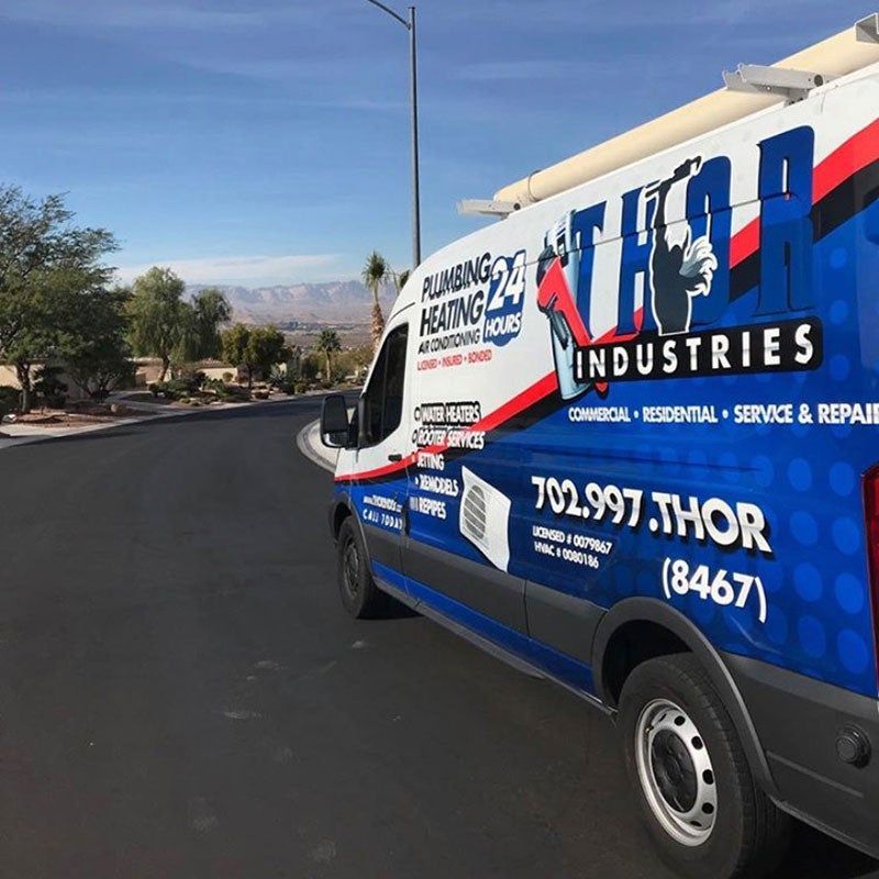 A plumbing and heating van is parked on the side of the road