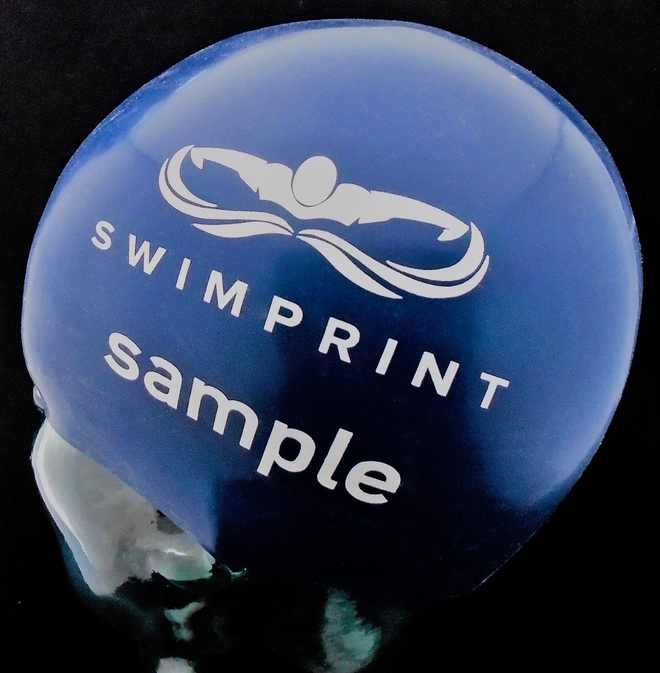 Eine blaue Badekappe mit der Aufschrift „Swimprint Sample“