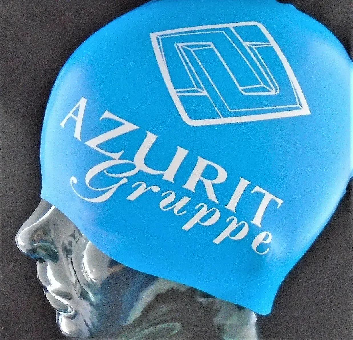 Eine blaue Badekappe mit der Aufschrift „Azurit Gruppe“.