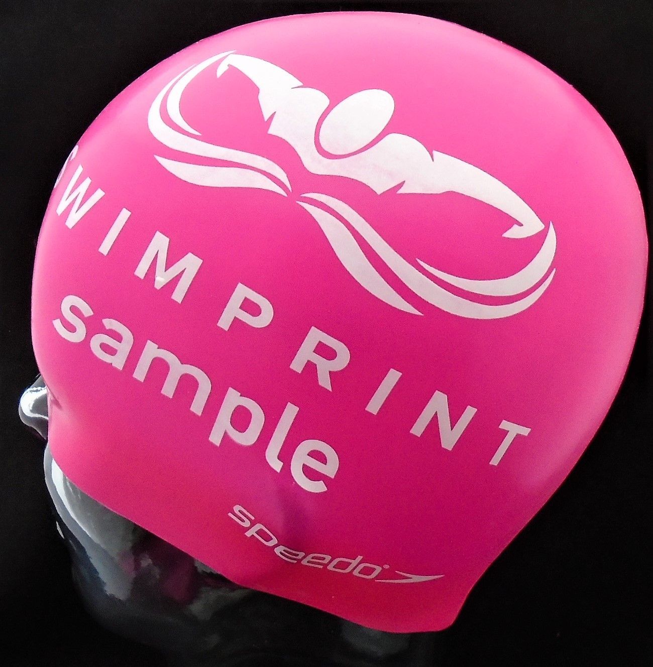 Eine rosa Badekappe mit der Aufschrift „Wimp Print Sample“ darauf