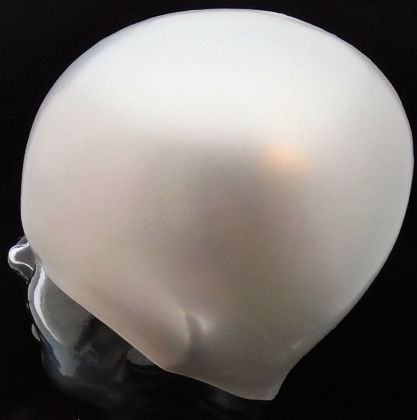 Eine weiße Badekappe ist auf einem Schaufensterpuppenkopf