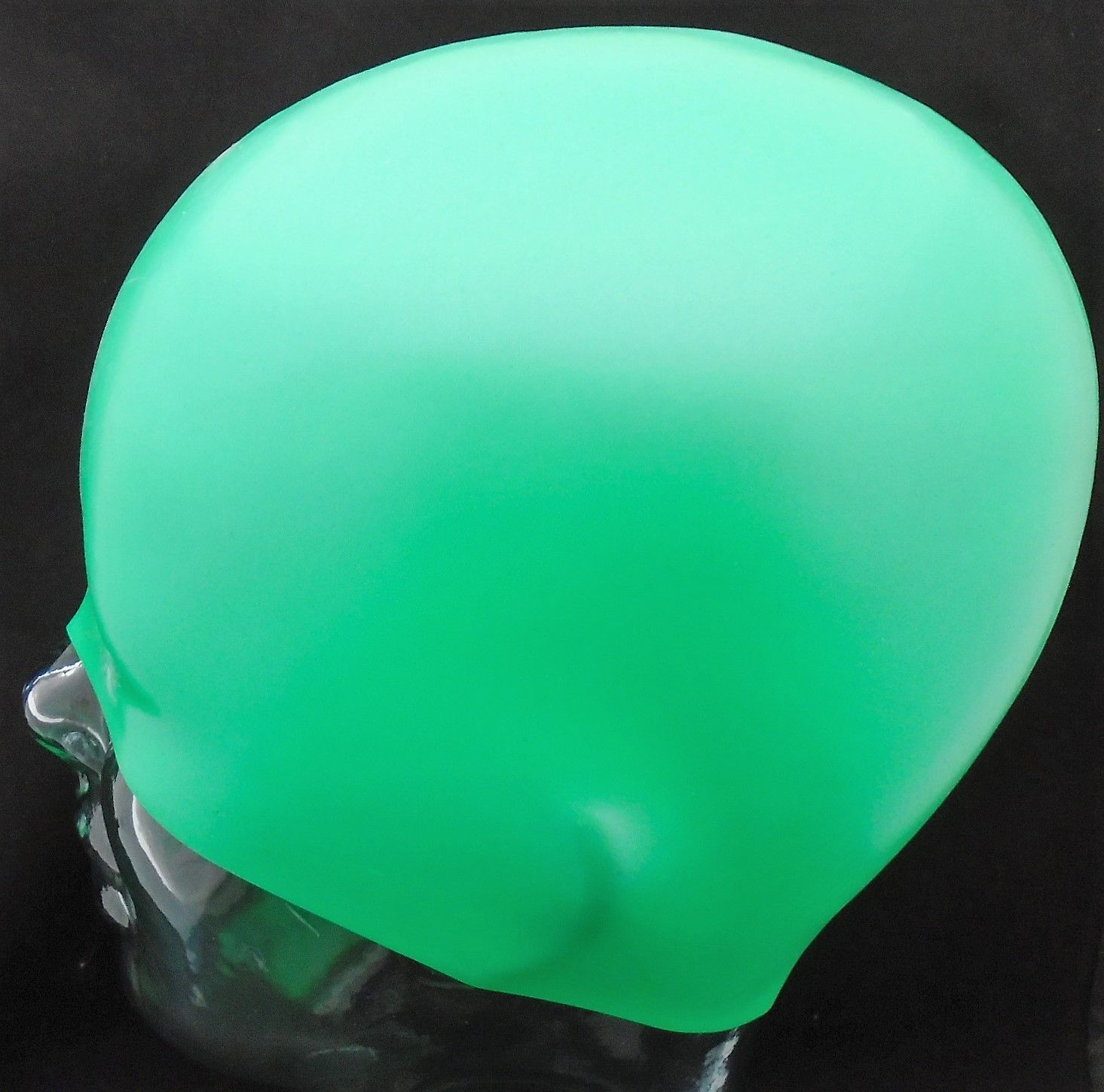 Eine grüne Badekappe ist auf einem Schaufensterpuppenkopf