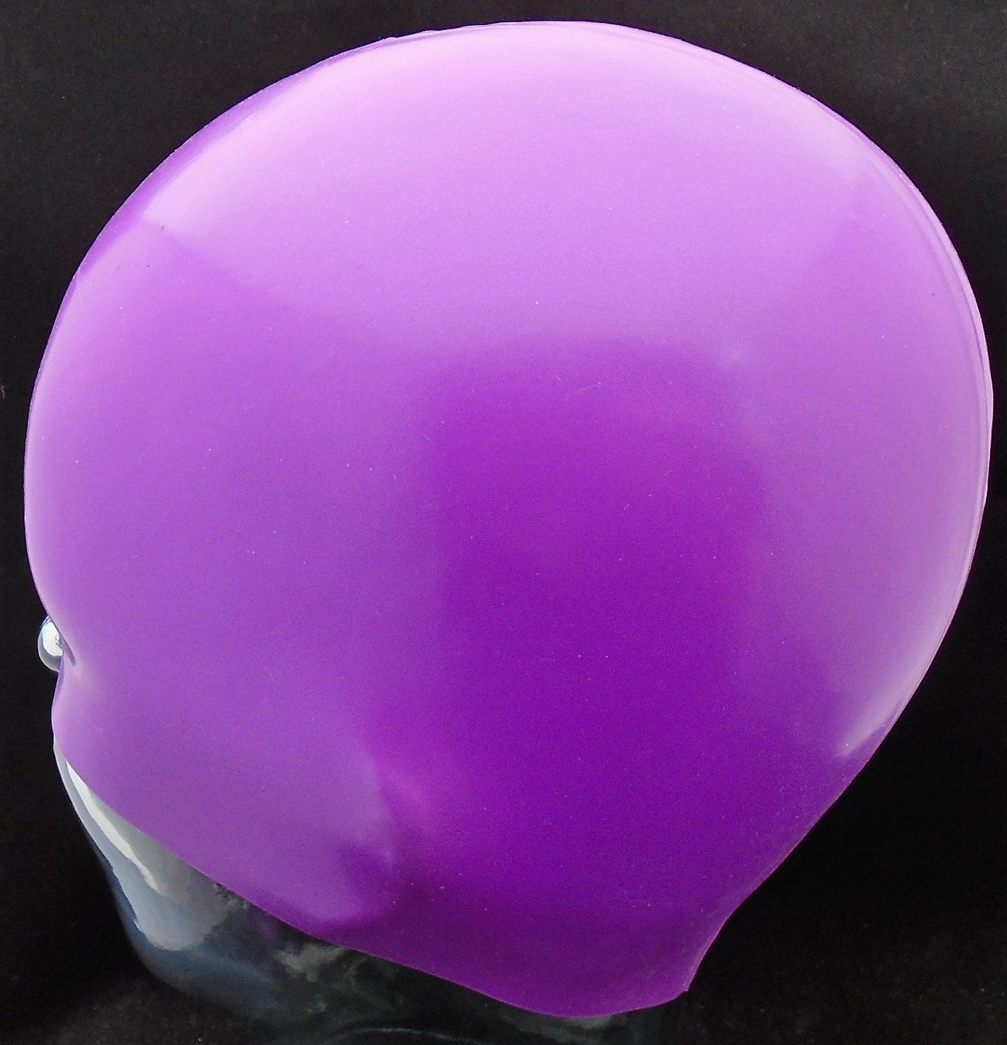 Ein lila Ballon liegt auf einer schwarzen Oberfläche