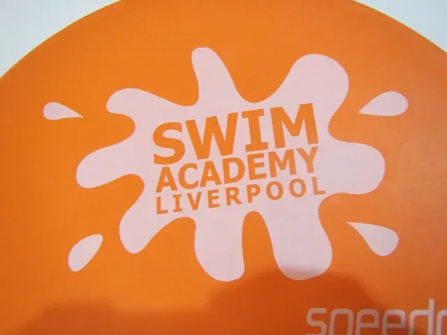 Ein orangefarbenes Schild mit der Aufschrift „Swim Academy Liverpool“.