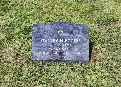 A red rose is laying on top of a grave.