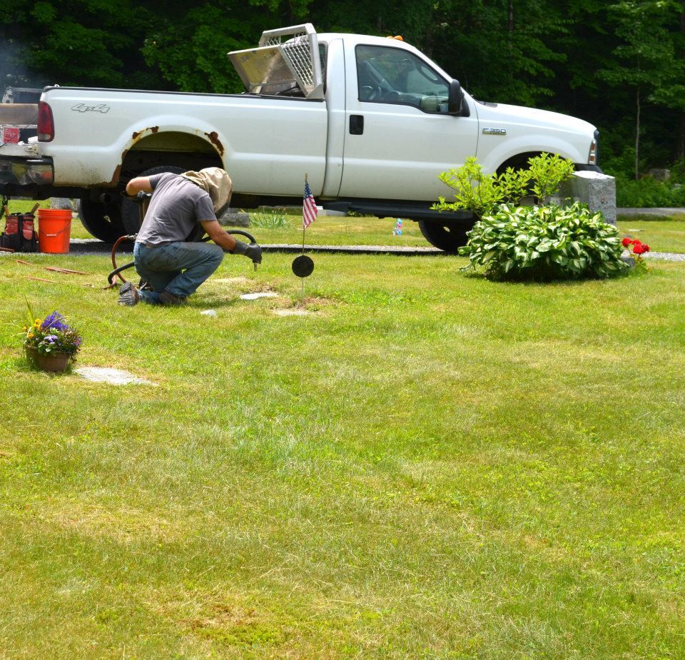 A cemetery filled with graves and trees on a sunny day.