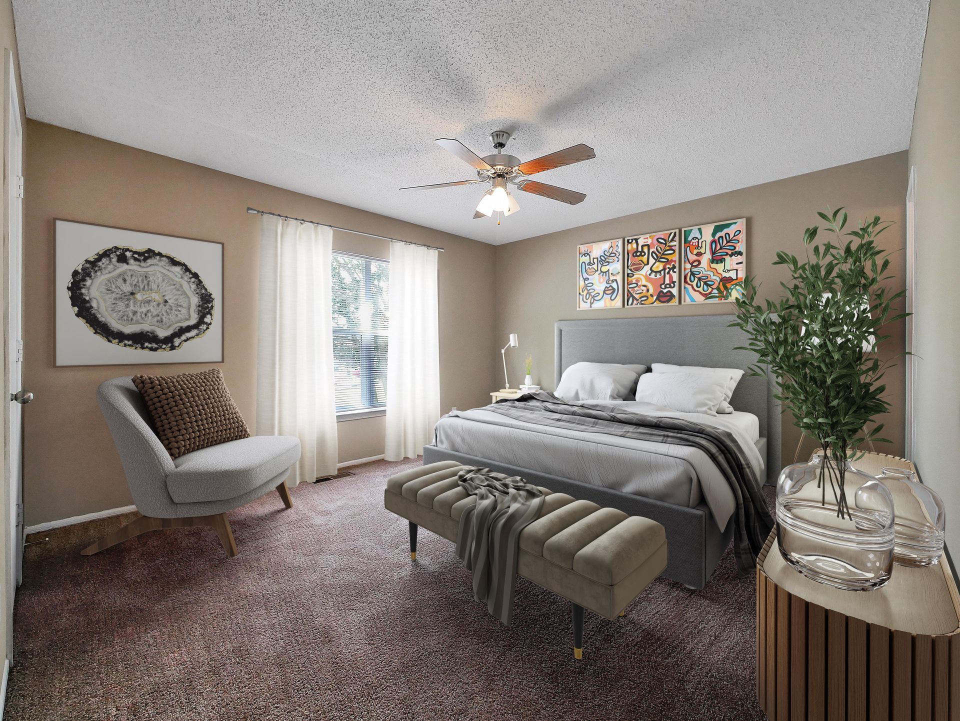 A bedroom with a queen bed, gray upholstered headboard, tufted bench, an armchair, and art on beige walls.