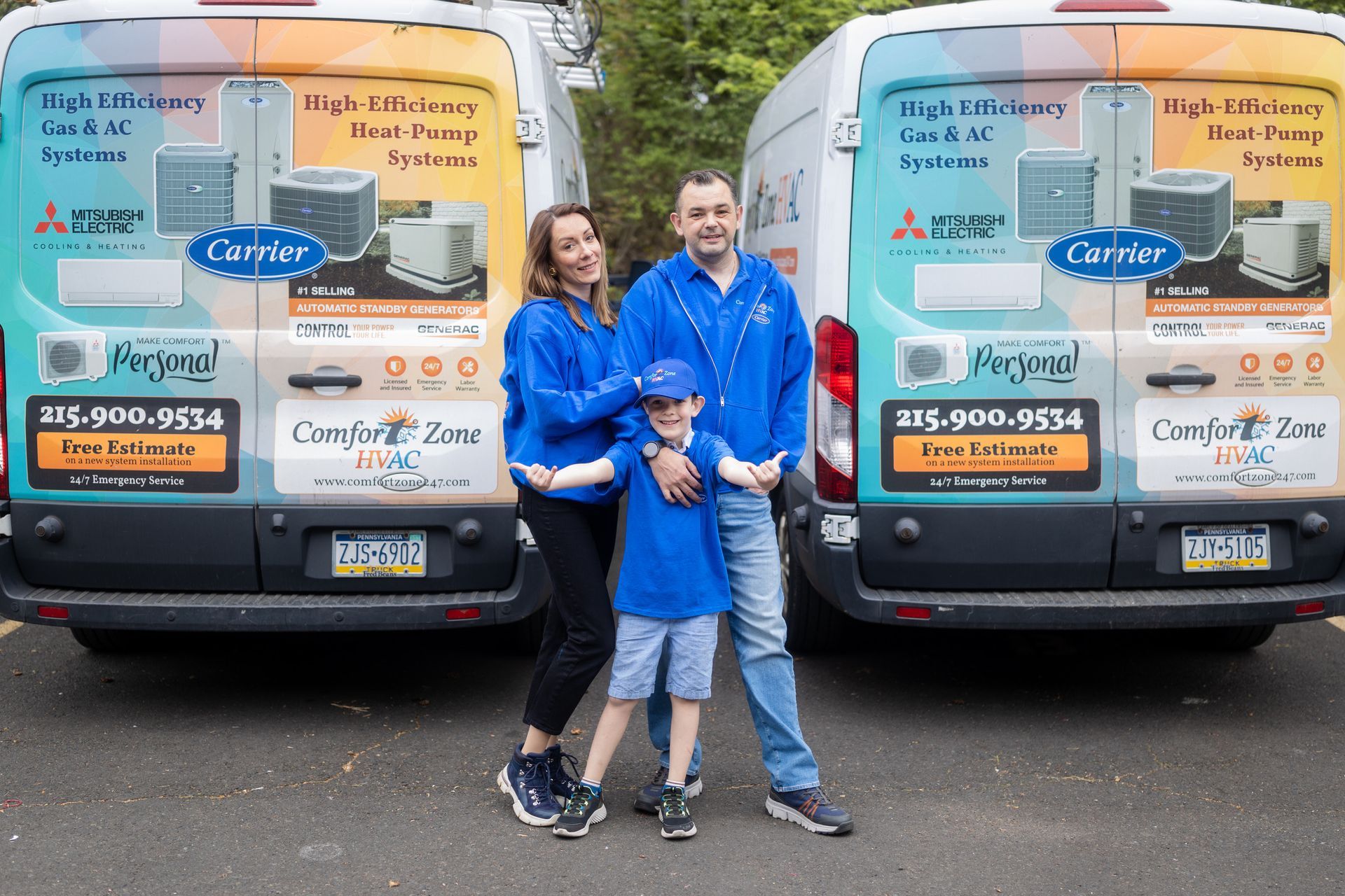 A family is posing for a picture in front of two vans.