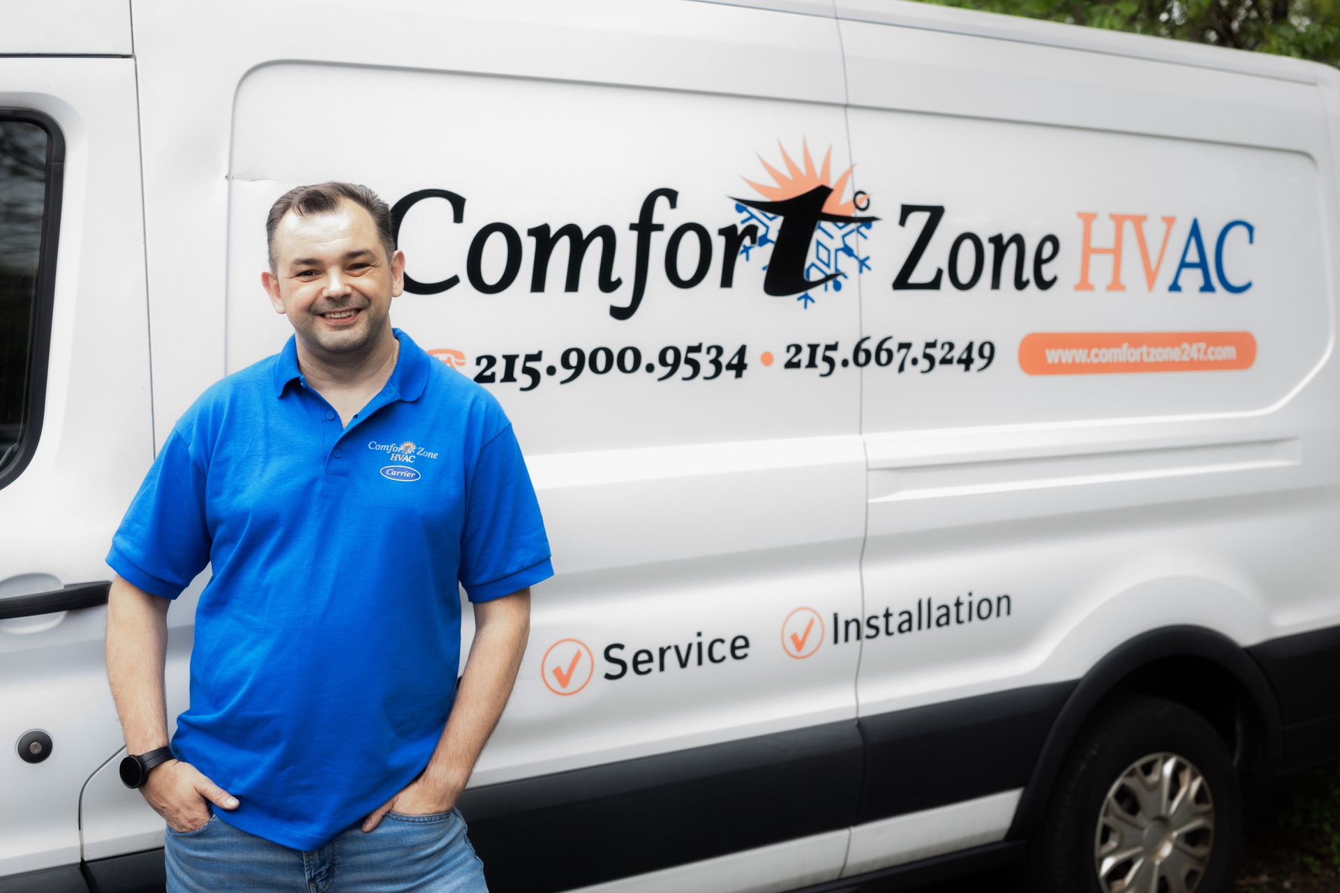 A man is standing in front of a comfort zone hvac van