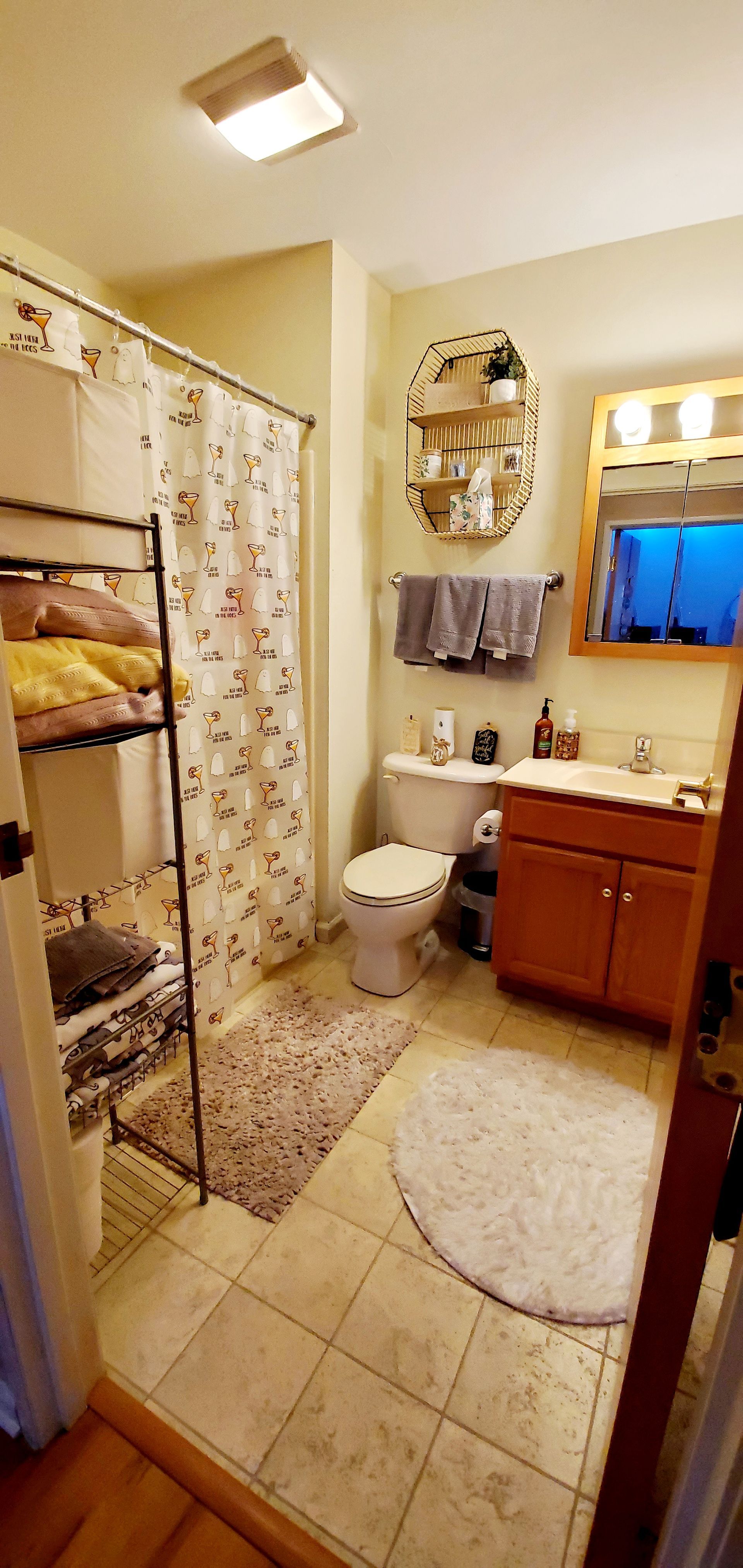A bathroom with a toilet , sink , and shower curtain.