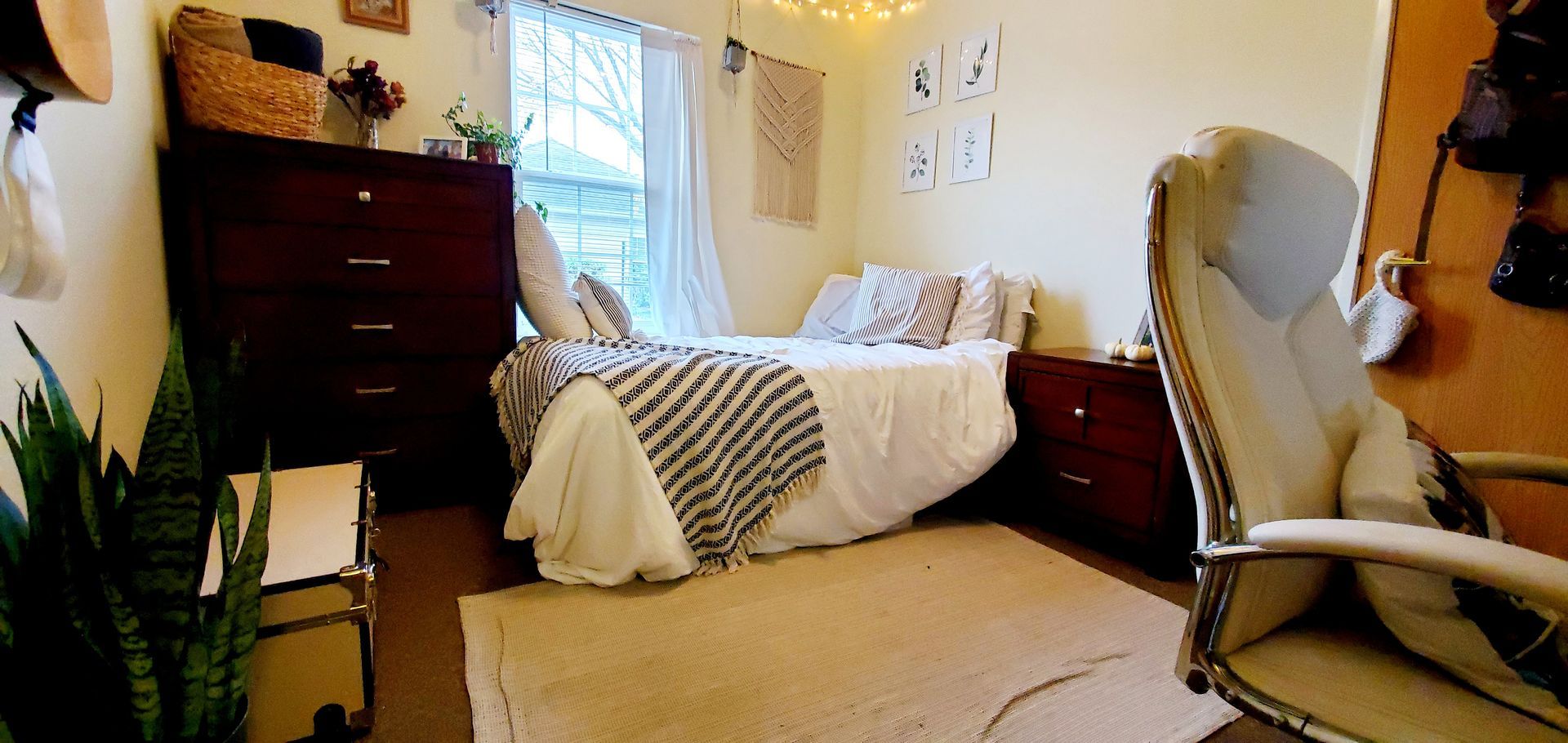 A bedroom with a bed , dresser , nightstand , chair and rug.