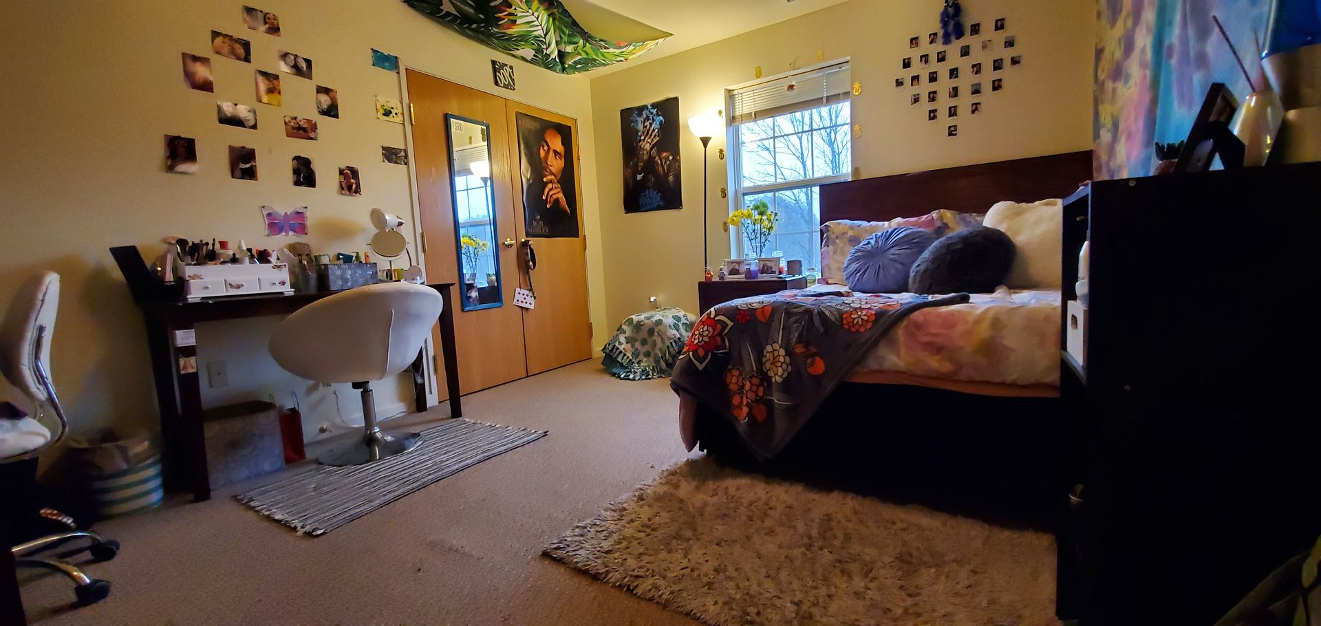 A bedroom with a bed , desk , chair and rug.