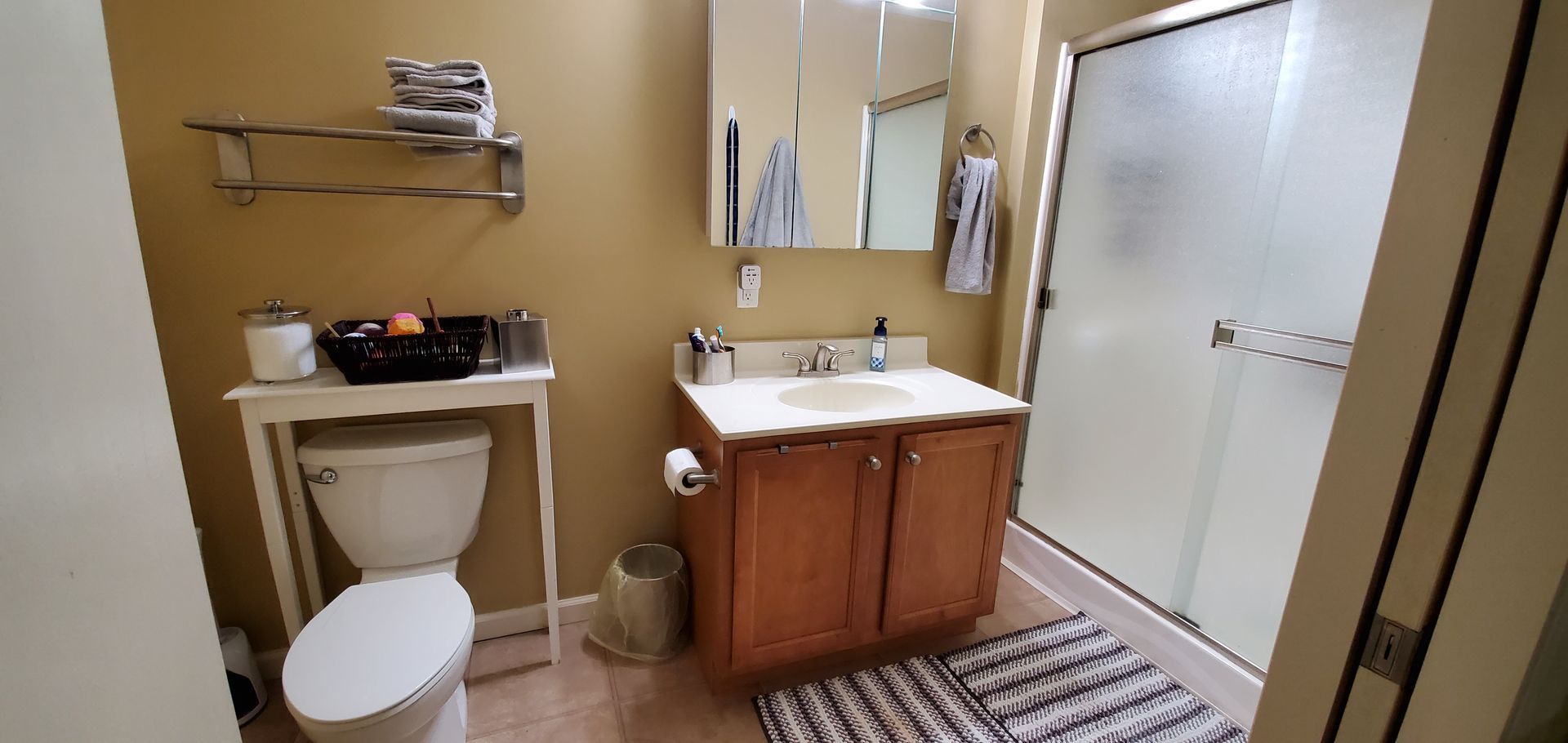 A bathroom with a toilet , sink , and shower.