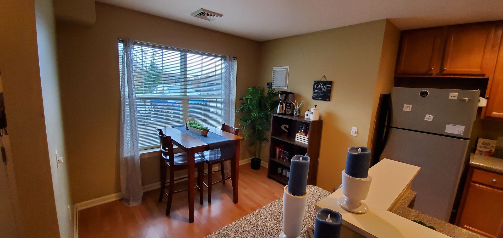 A kitchen with a table and chairs and a refrigerator.