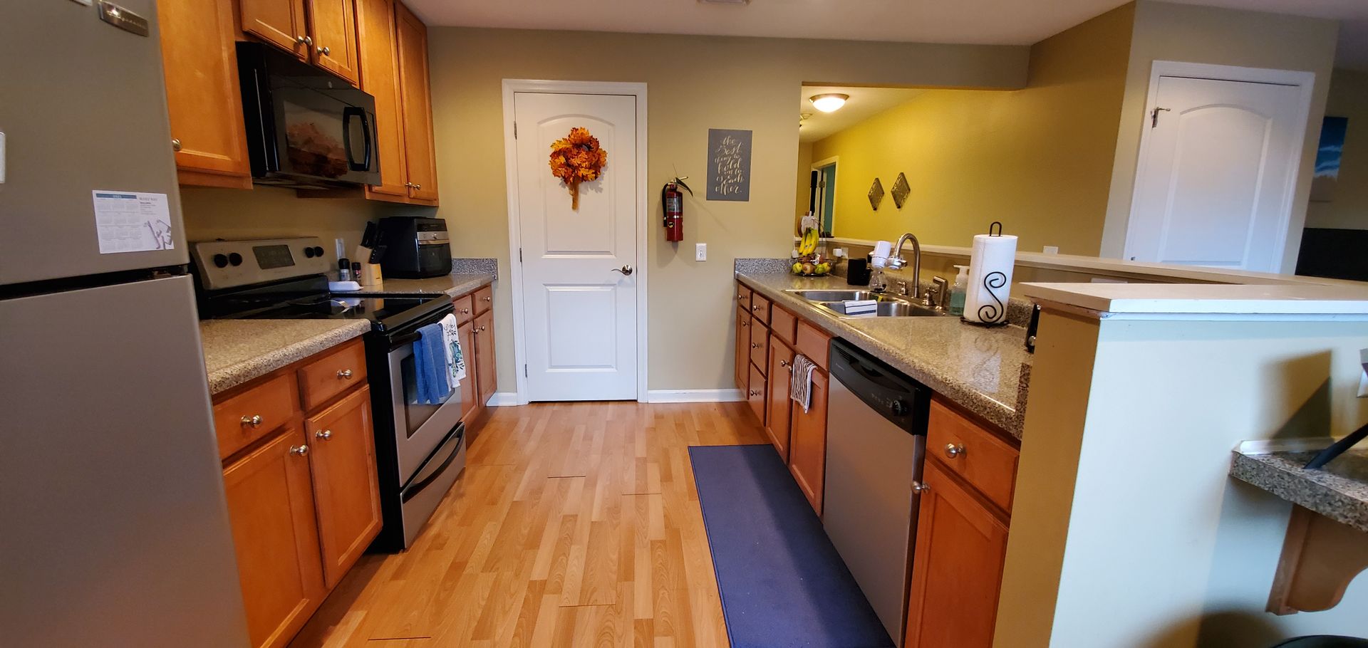 A kitchen with stainless steel appliances and wooden cabinets.