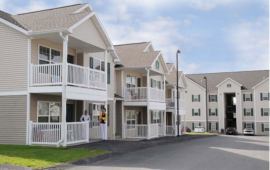 A row of apartment buildings with white balconies and shutters