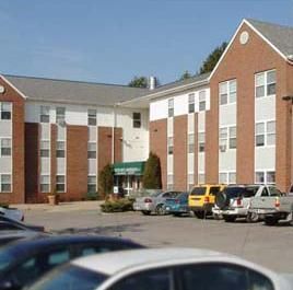 A large brick apartment building and parking lot.