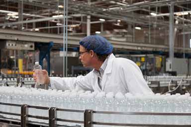 Factory Worker Examining Bottled Water — New Bedford, MA — Associated Career Network LLC