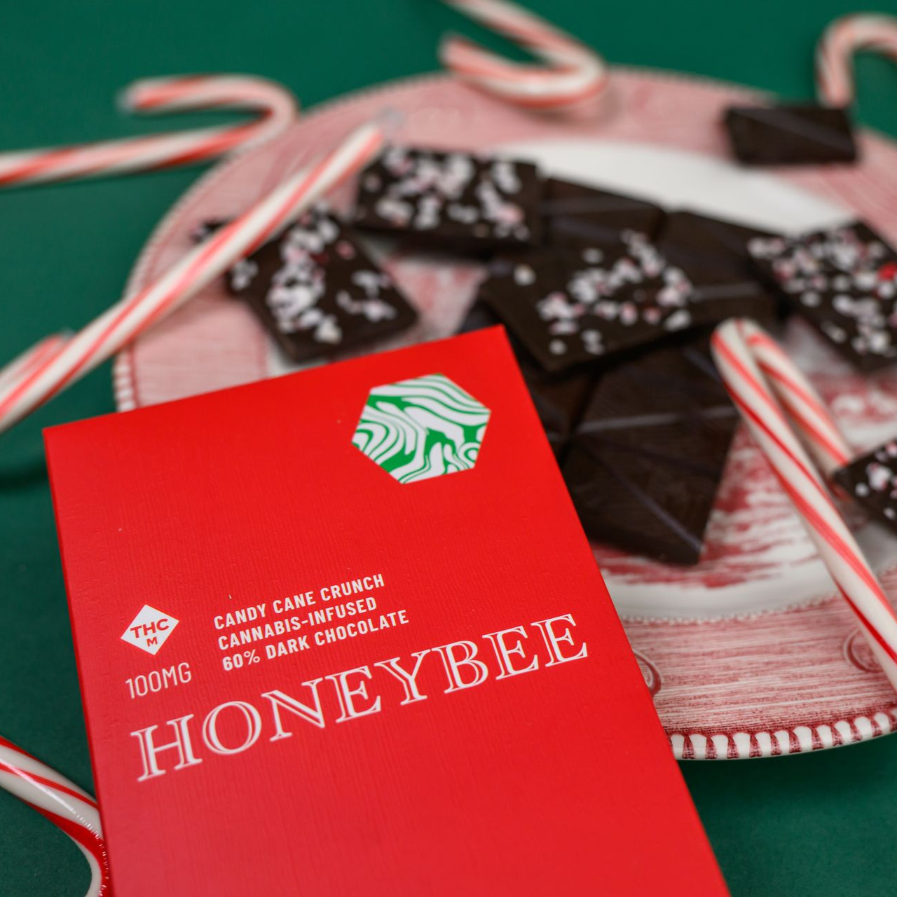 A person is holding a piece of orange candy in their hand.