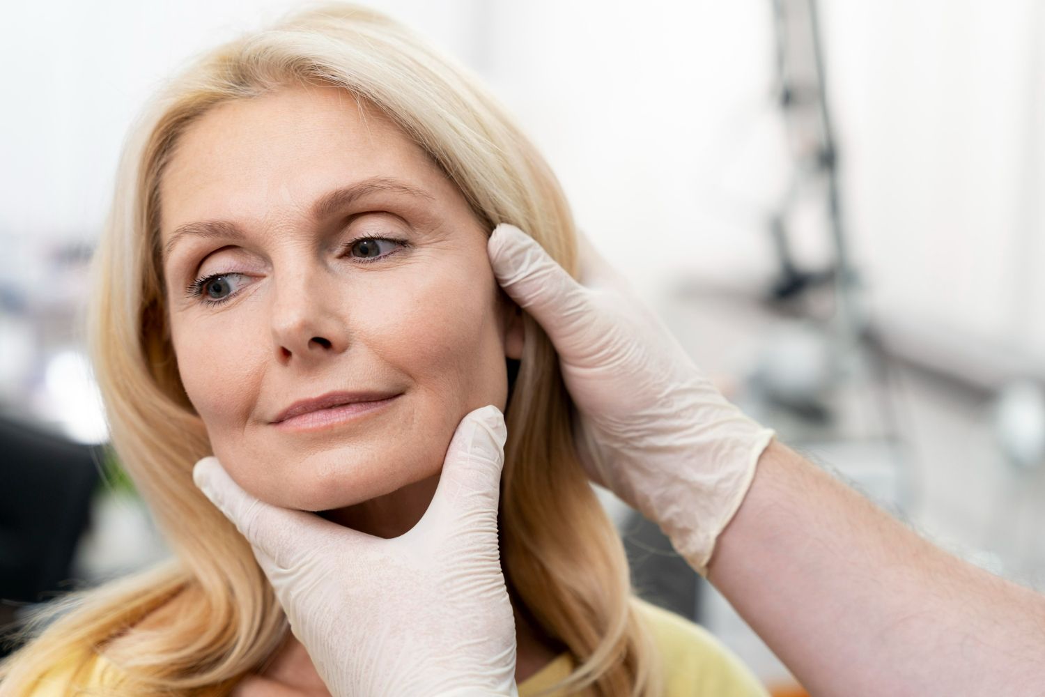 A woman is getting her face examined by a doctor.