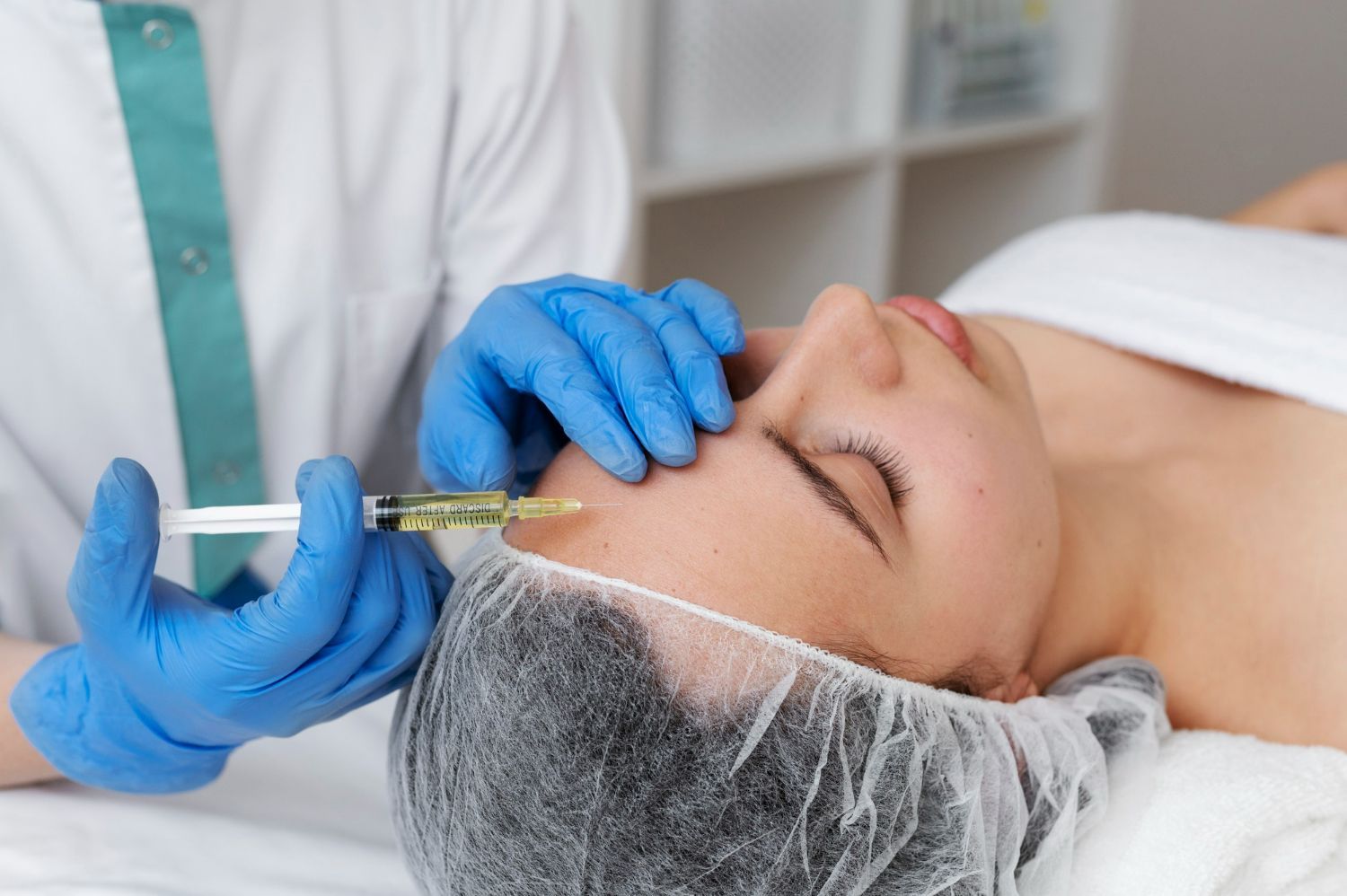 A woman is getting a botox injection in her forehead.