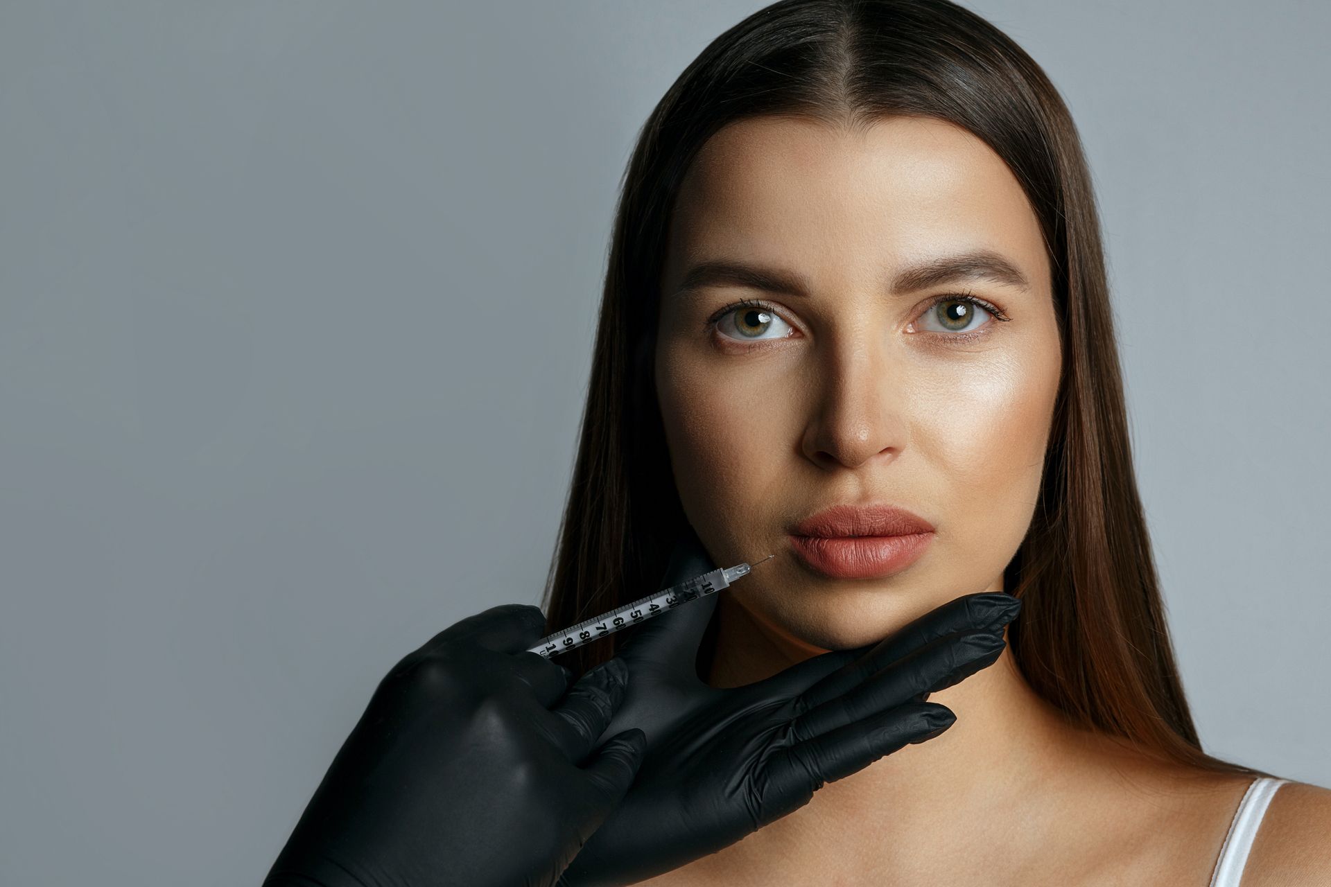 A woman is getting a botox injection in her face.