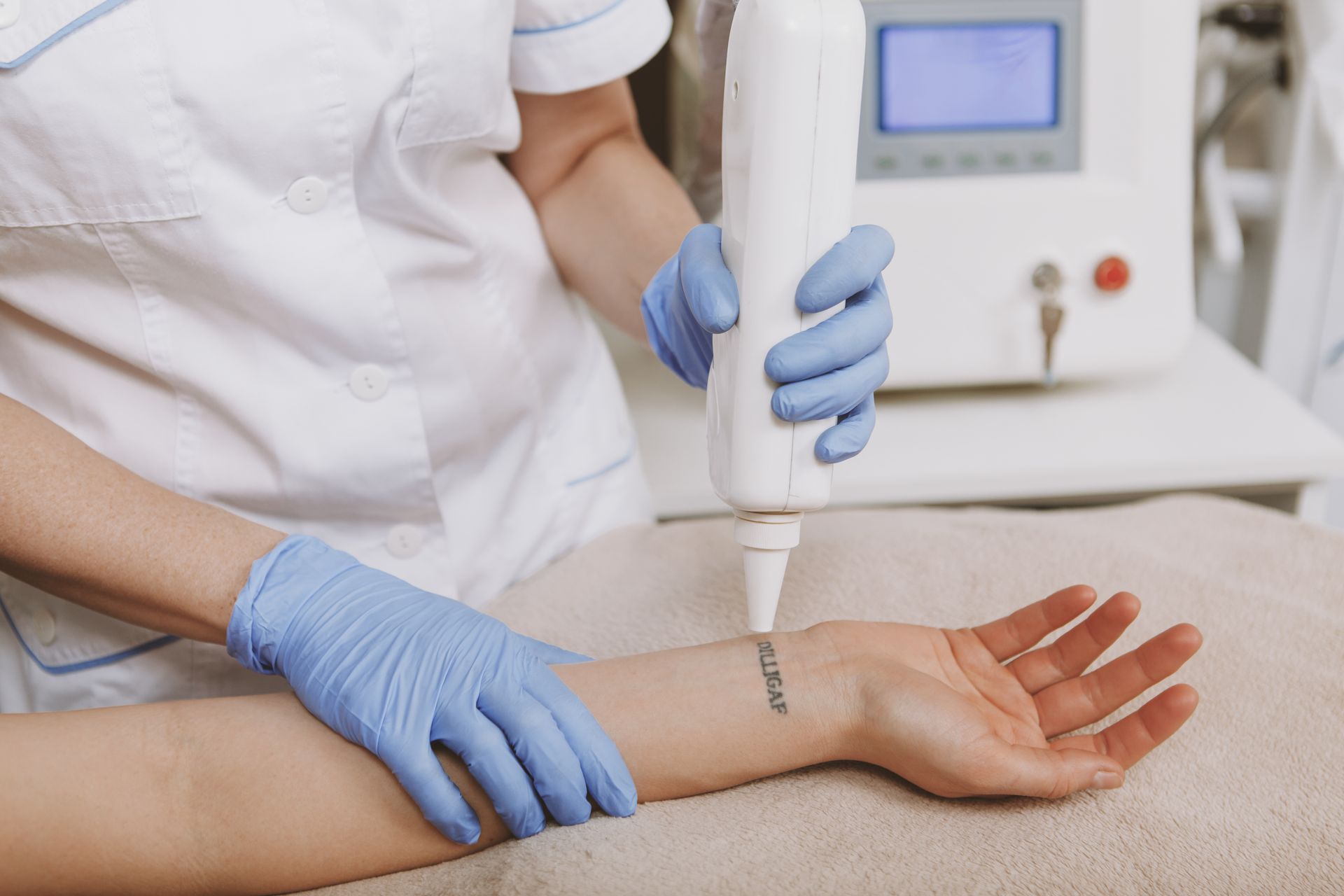 A woman is getting a tattoo removed from her wrist.