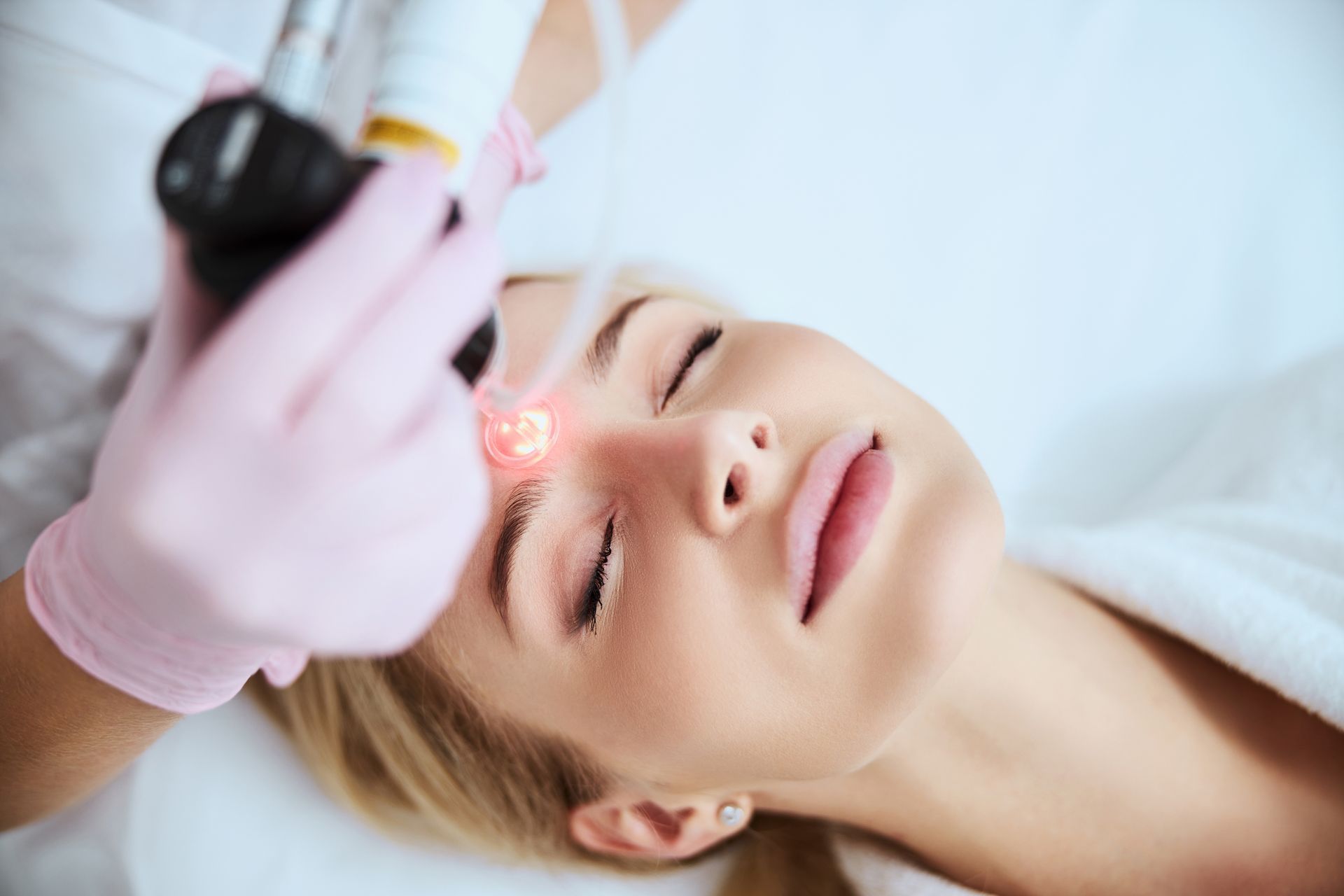 A woman is getting a laser treatment on her face.