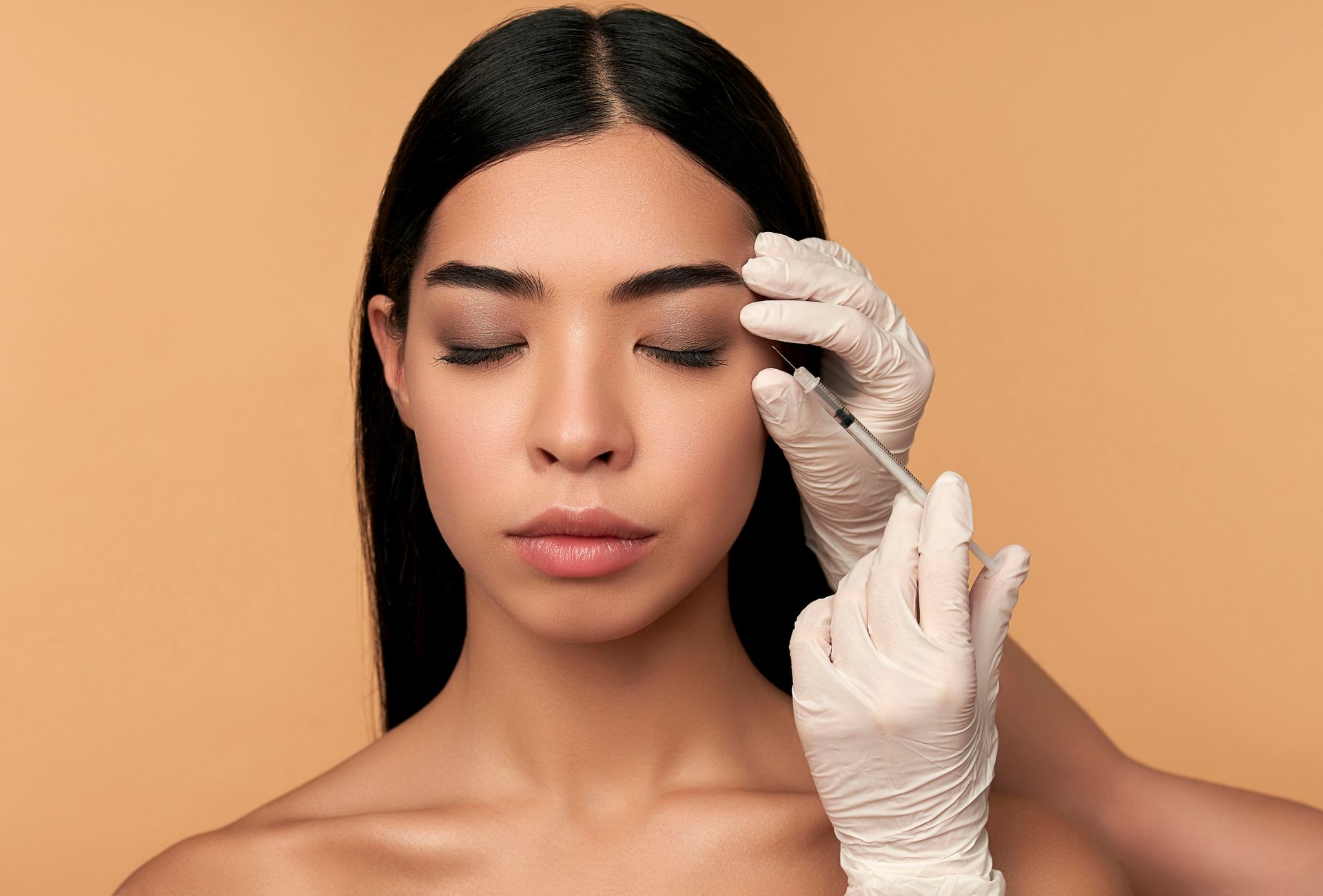 A woman is getting an injection in her eyebrows.