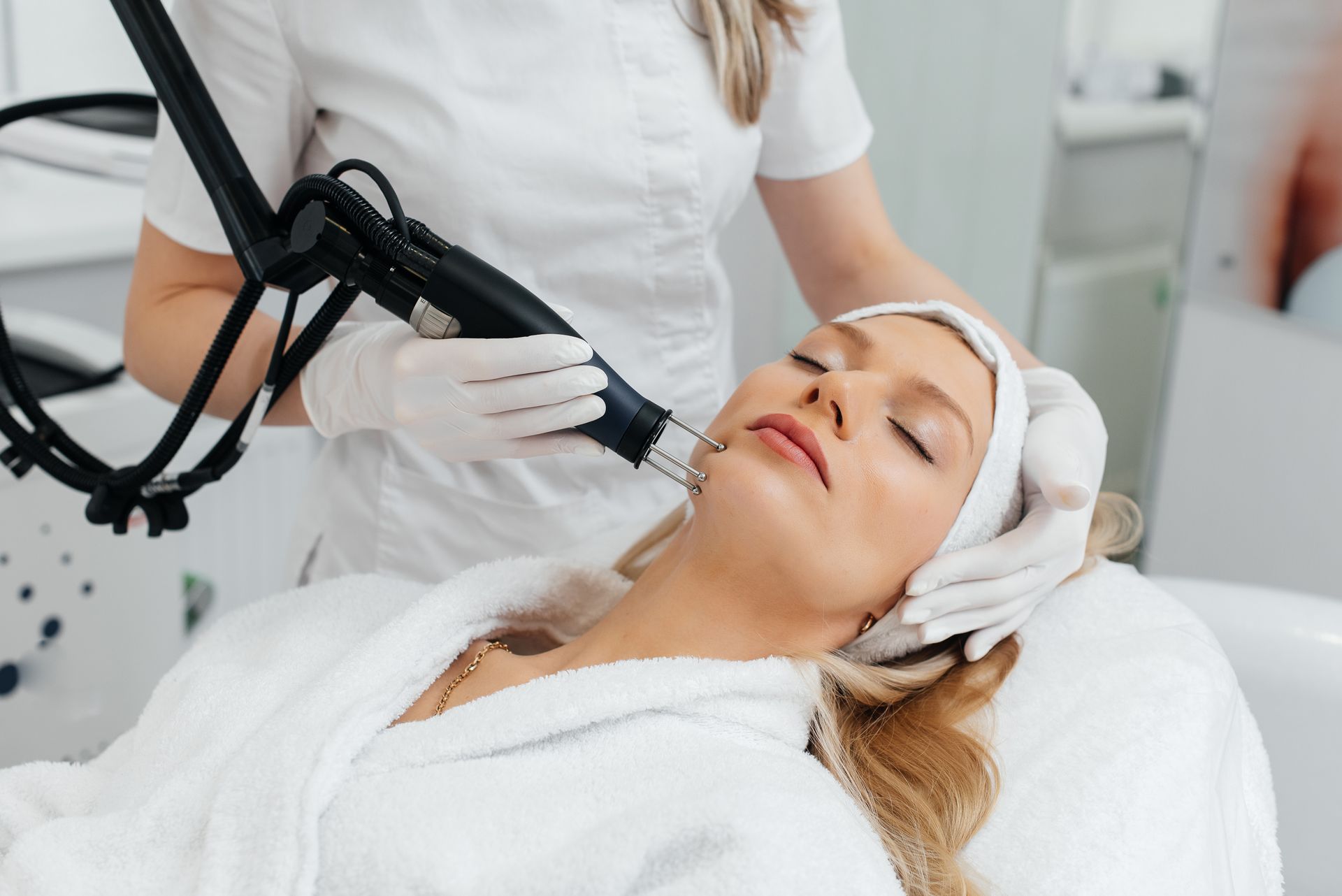 A woman is getting a laser treatment on her face.