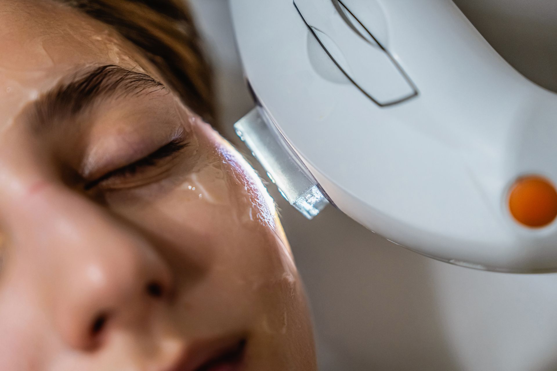 A woman is getting a laser treatment on her face.