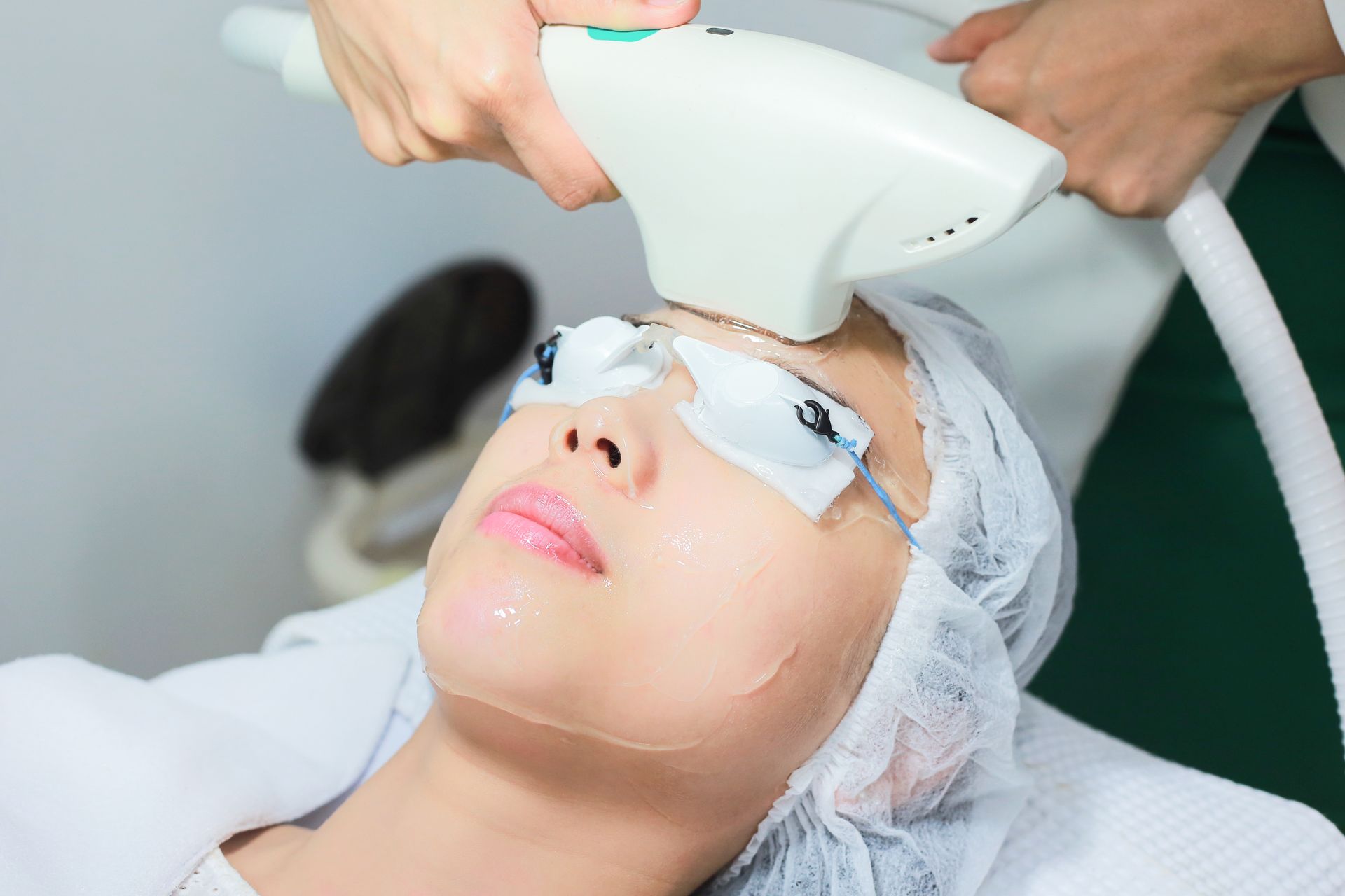 A woman is getting a laser treatment on her face.