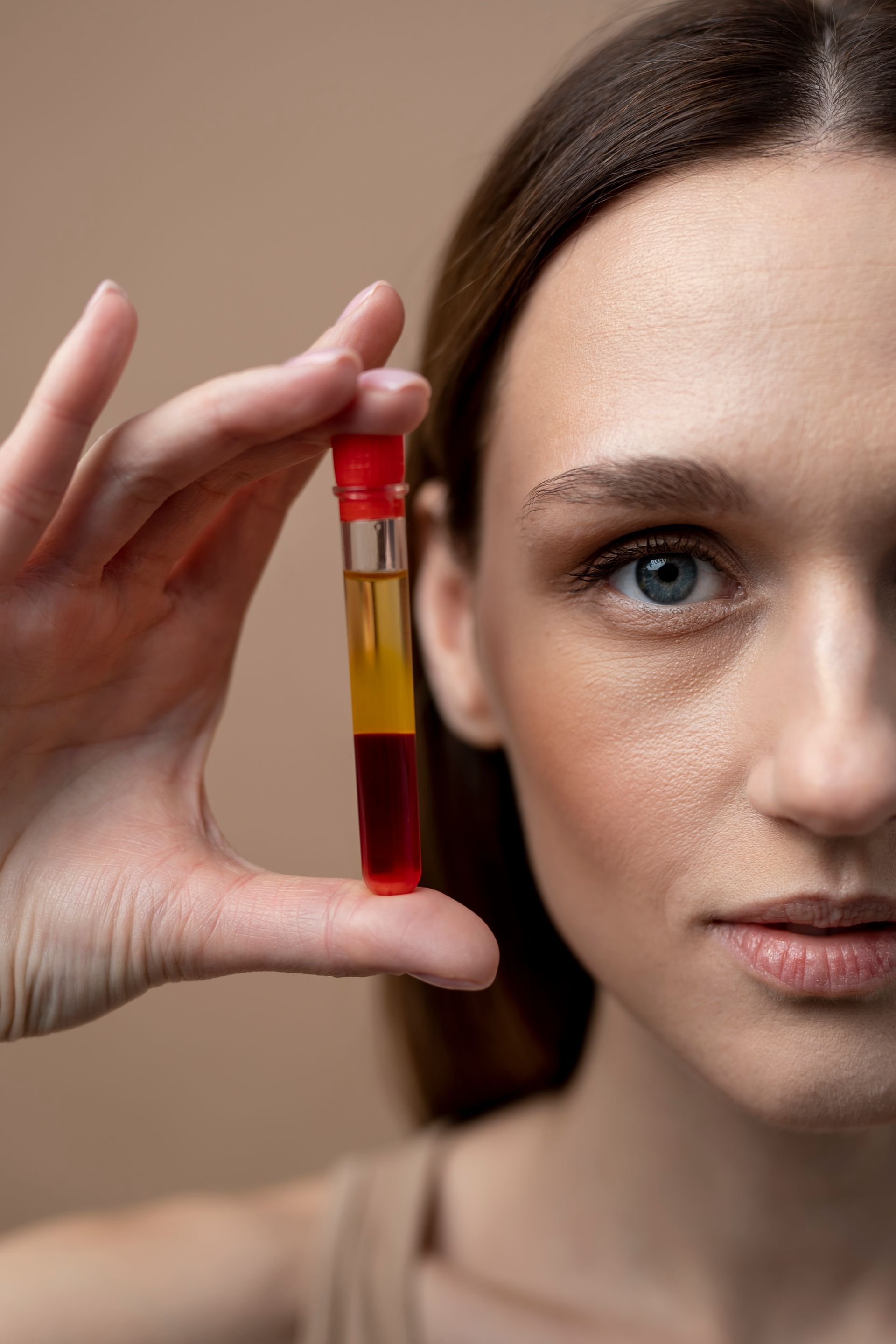 A woman is holding a test tube in her hand.