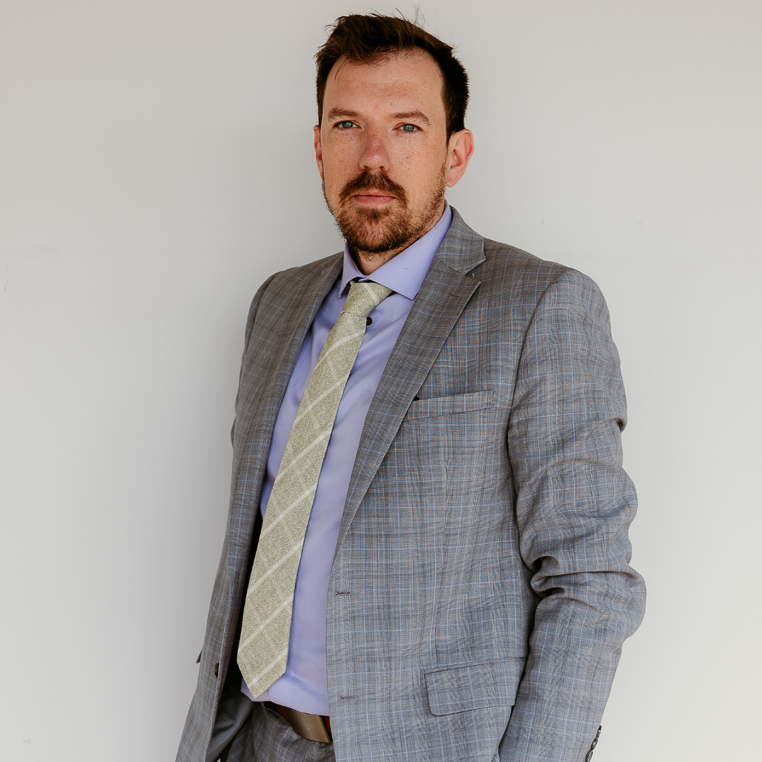 a personal injury attorney in a suit and tie is adjusting his cufflinks