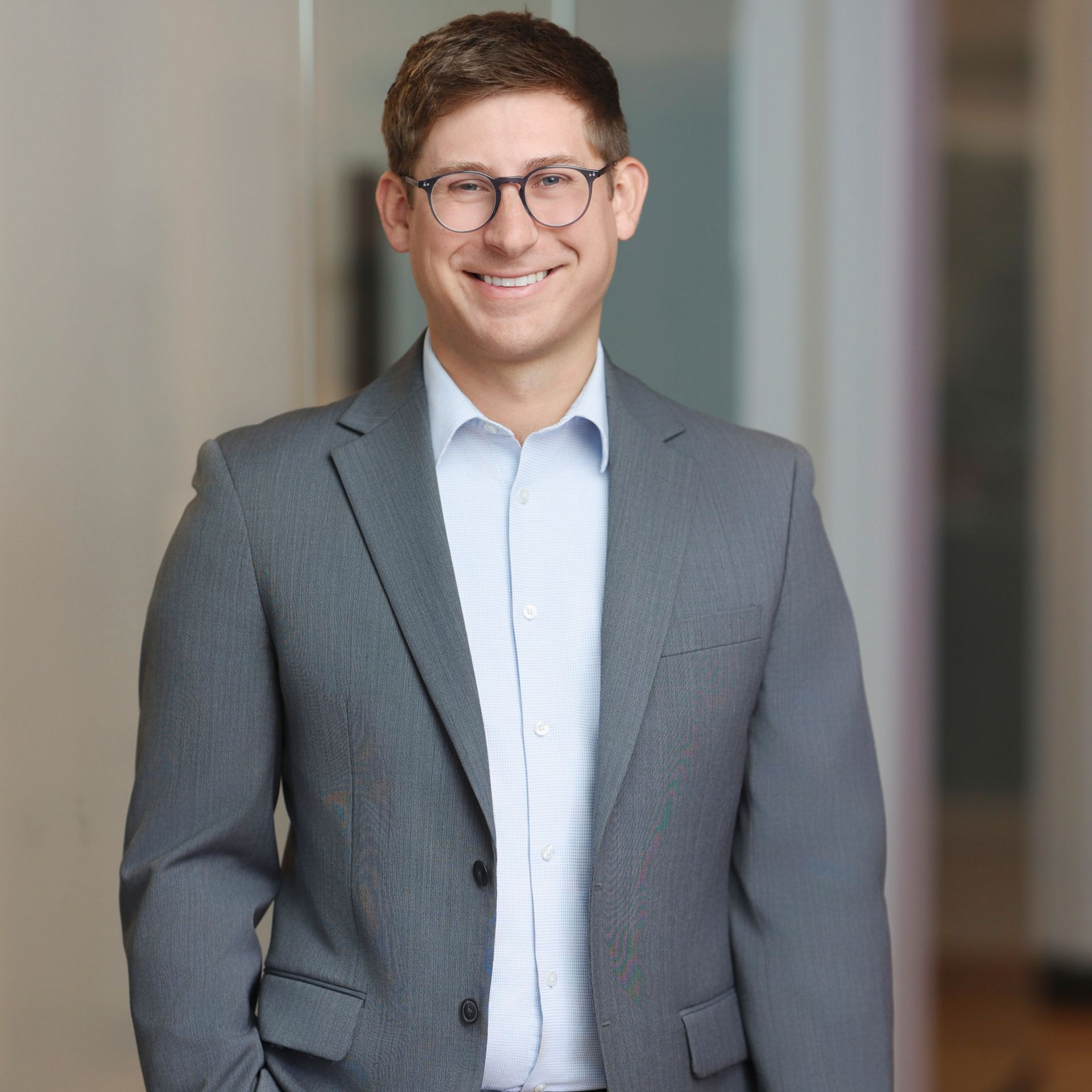a personal injury attorney in a black top and green skirt is sitting on a stool .