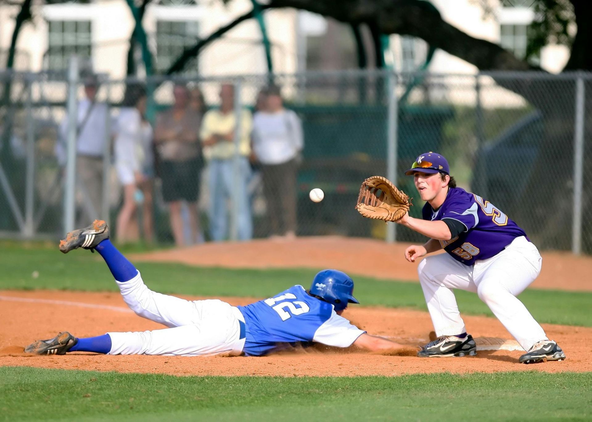 A baseball player with the number 23 on his jersey is sliding into base