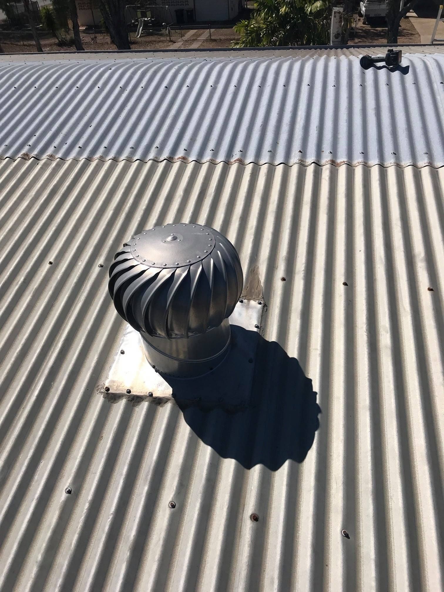 A Metal Turbine Vent Sits on a Corrugated Metal Roof — Top To Bottom Plumbing in Garbutt, QLD