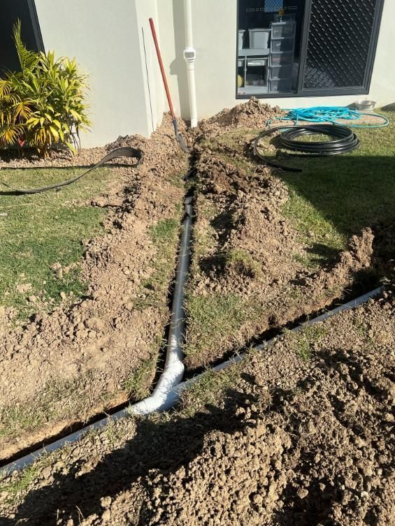 A Hose Is Laying in The Dirt in Front of A House — Top To Bottom Plumbing in Garbutt, QLD